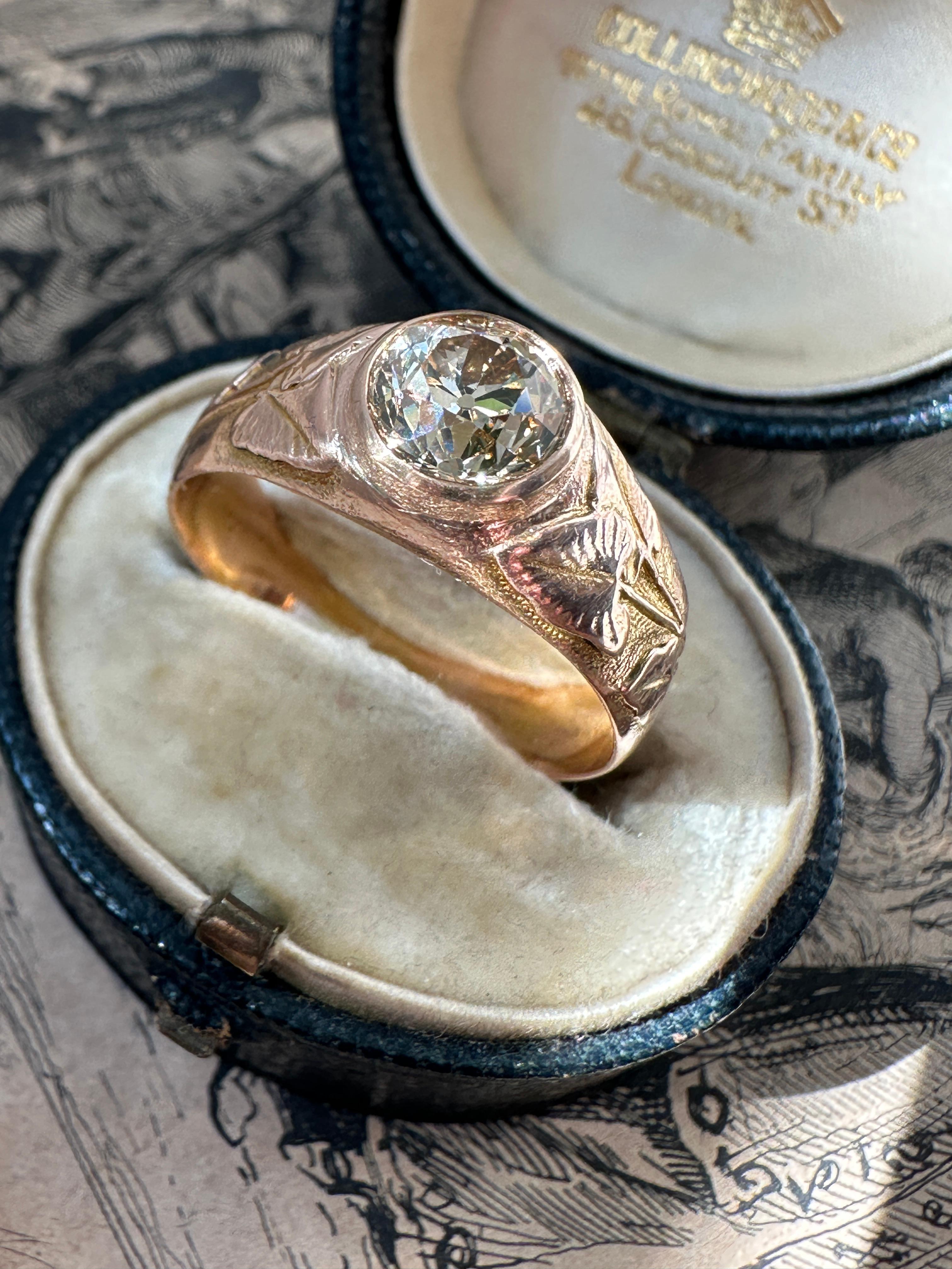 Dating to the turn of the 20th century Russia, a golden light brown 1.29 carat cushion cut diamond radiates from between calla lilly embellished shoulders. Finely fabricated in a burnished 14 karat rose gold. Currently a ring size 9. Accompanied by