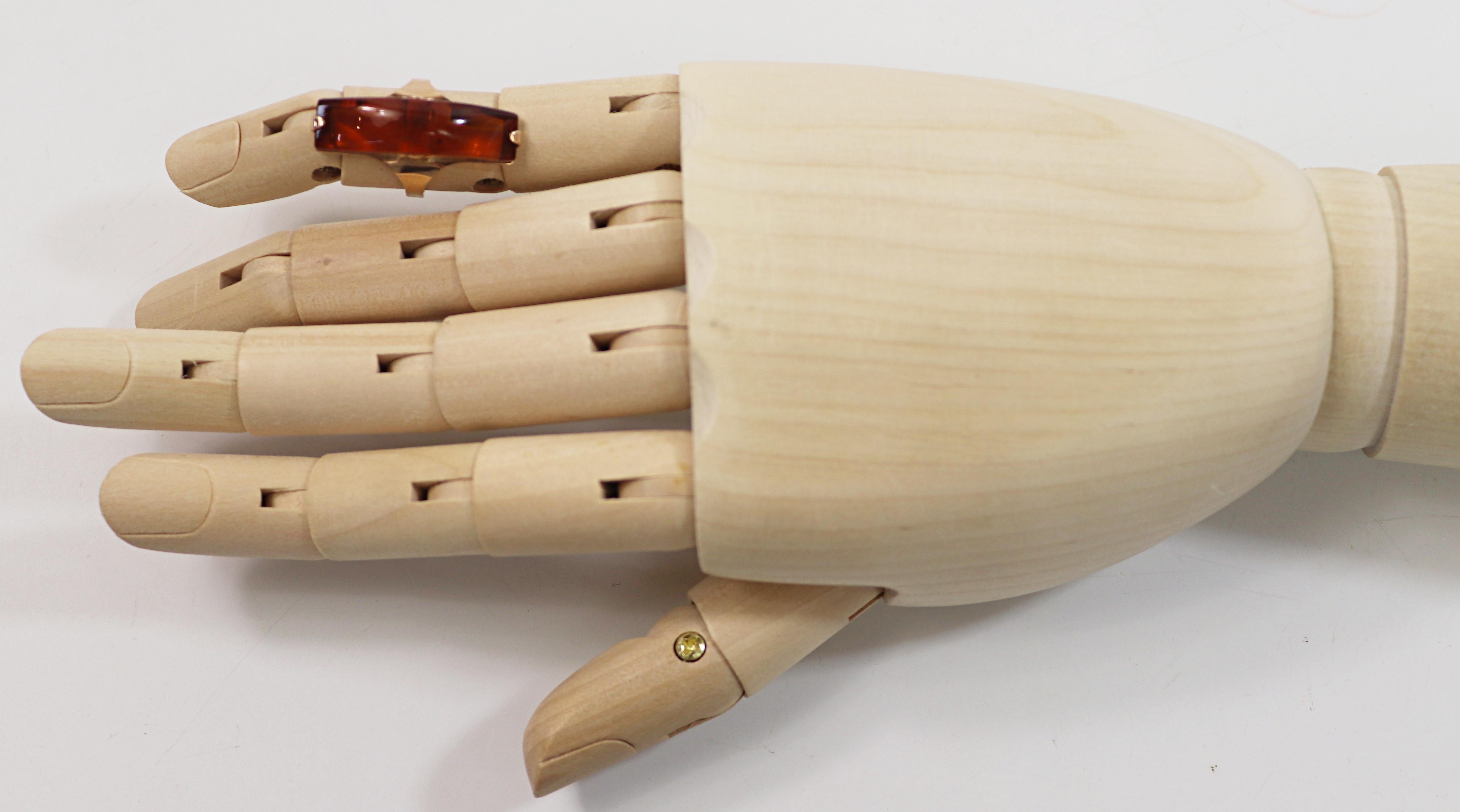 Featuring one honey colored amber wedge, 30 X 8.5 X 8.7 mm, set in a
14k rose gold geometric mounting, Russian hallmarks, size 6.5, Gross
Weight 4.24 grams.