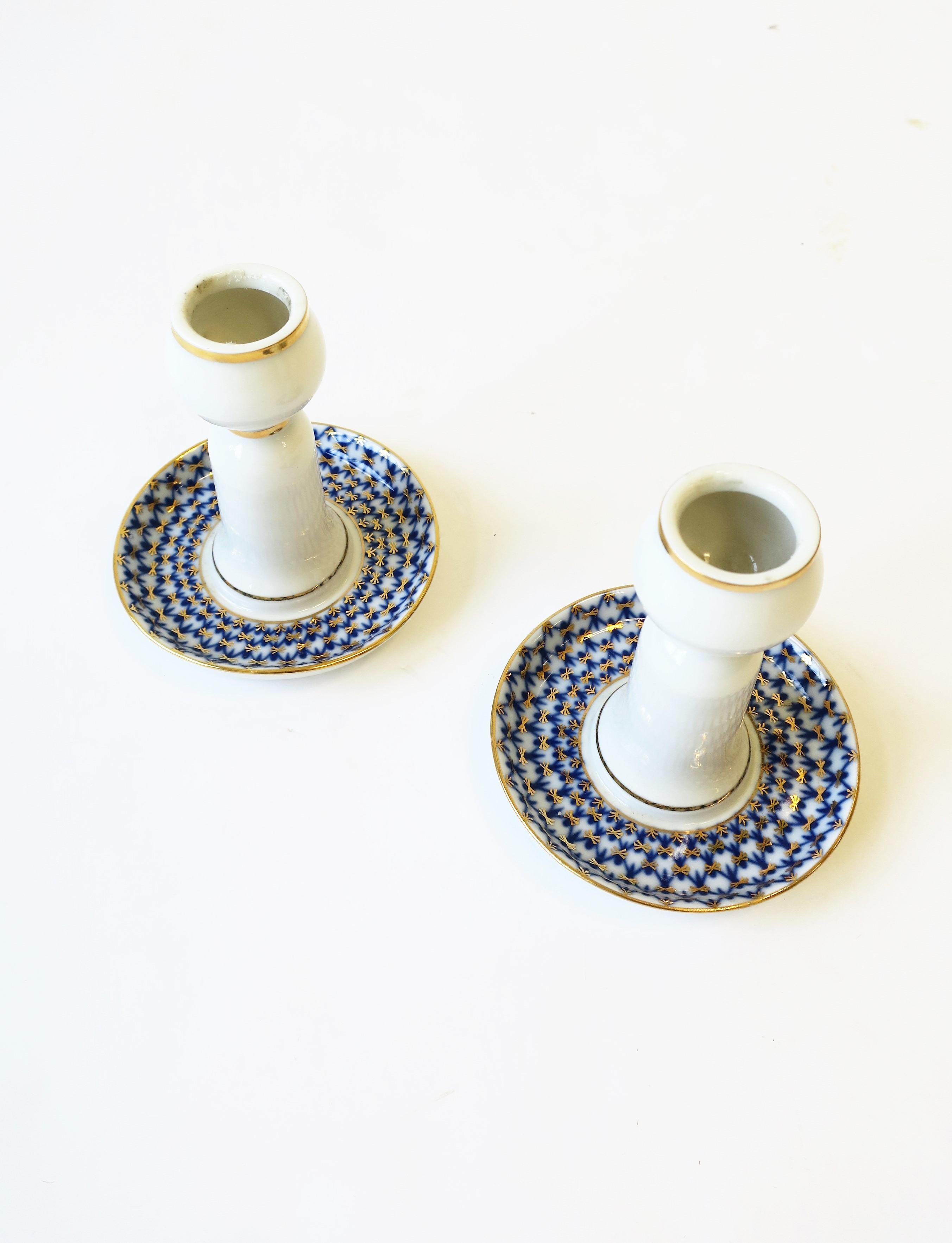 A pair of authentic Russian blue, gold and white porcelain candlestick holders in the 'Cobalt Net' pattern by Lomonosov Porcelain, Russia, circa late-20th century, after 1991. With maker's mark and marked 