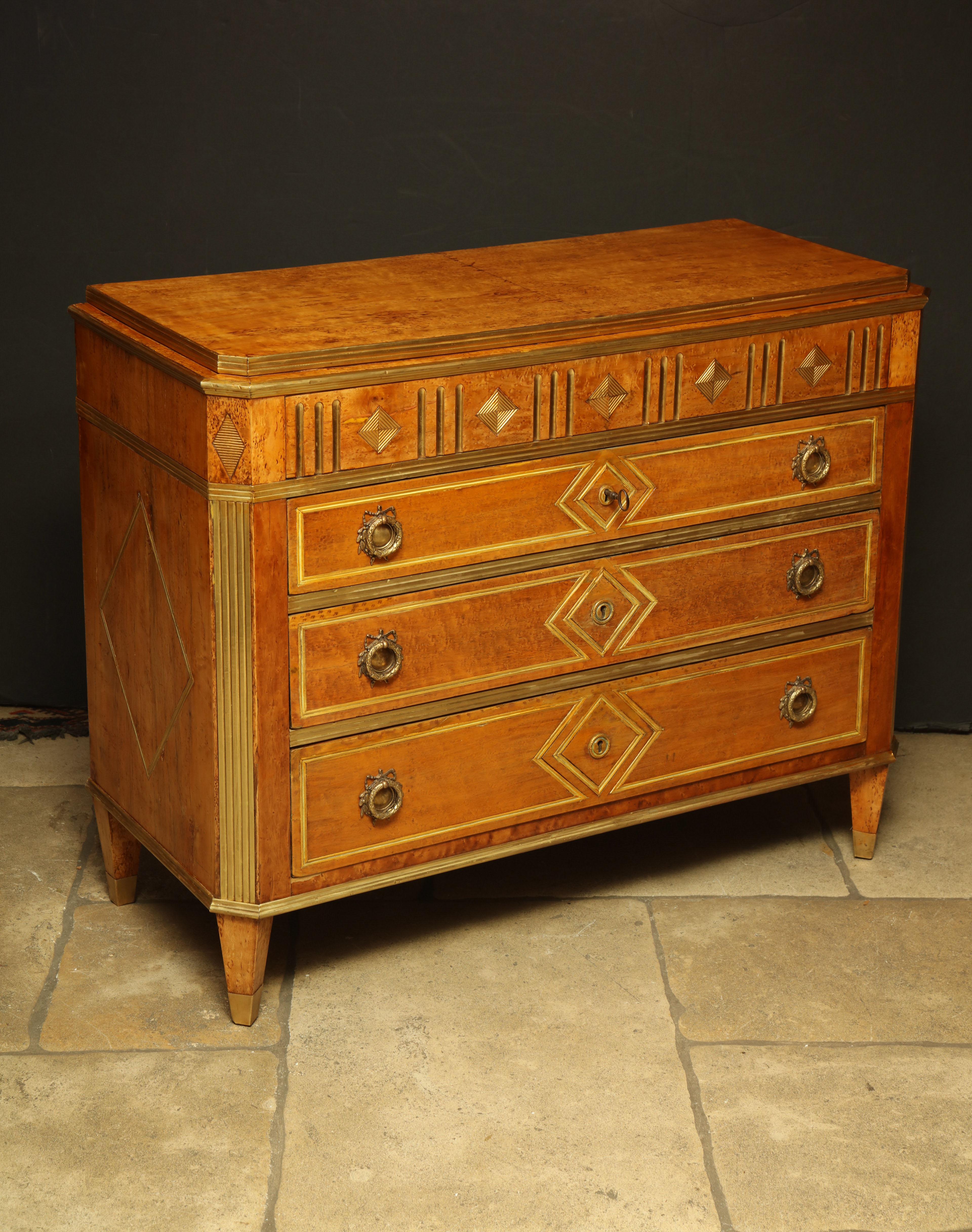 Fine Russian karelian birch brass trimmed and inlaid three-drawer commode with canted corners and tapered legs.