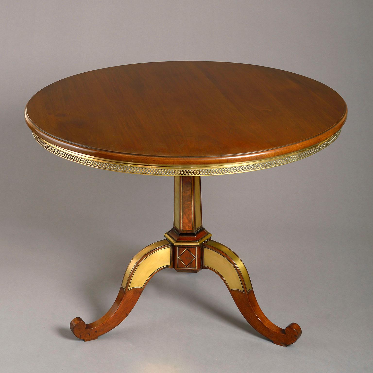 Russian brass inlaid mahogany gueridon table, the moulded circular top with unusual brass fretwork apron supported on a faceted tapering stem inlaid with alternating panels of brass and flame mahogany standing on a scrolling tripod base, also inlaid
