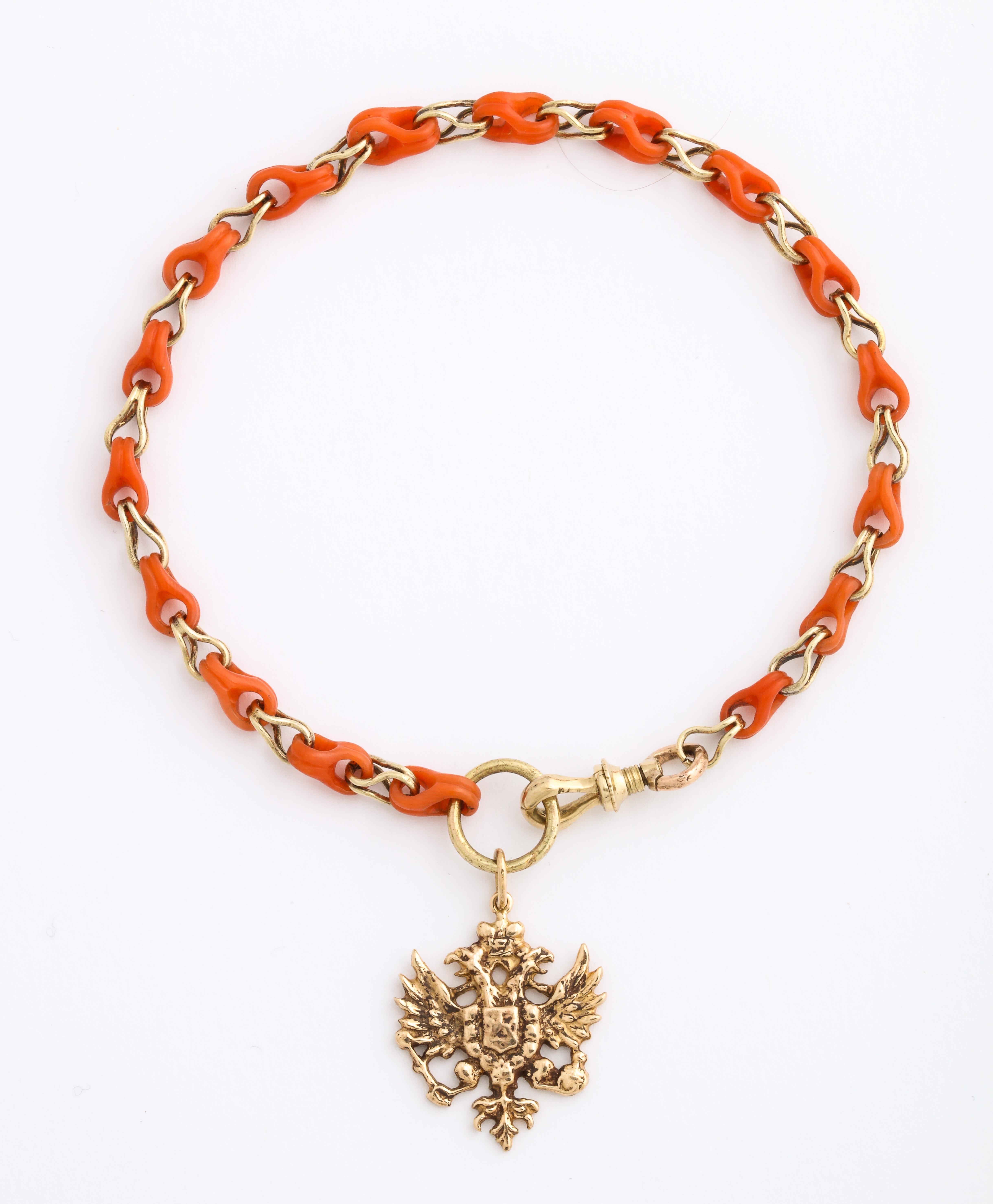From the Romanov era, a rare coral bracelet from Russia designed as seventeen carved open pear-shaped coral links alternating with openwork gold links of similar design. One end is fitted with a gold swivel clasp, the other with a large gold ring