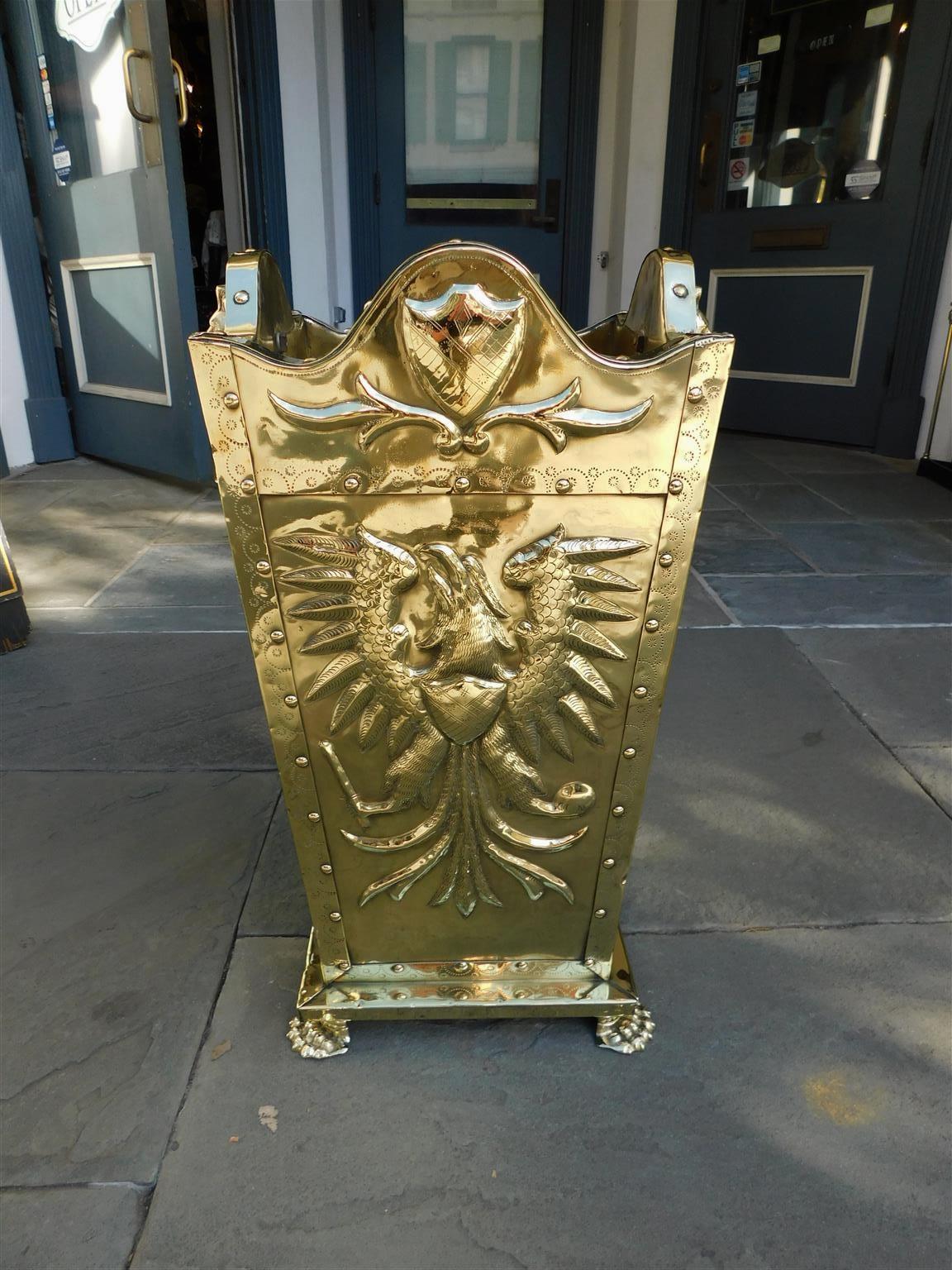 Russian embossed brass umbrella / walking stick stand with four serpentine studded panels decorated with eagle and shield motif, flanking lion head pulls, lead lined interior, and resting on a molded edge base with the original lion paw feet. Mid