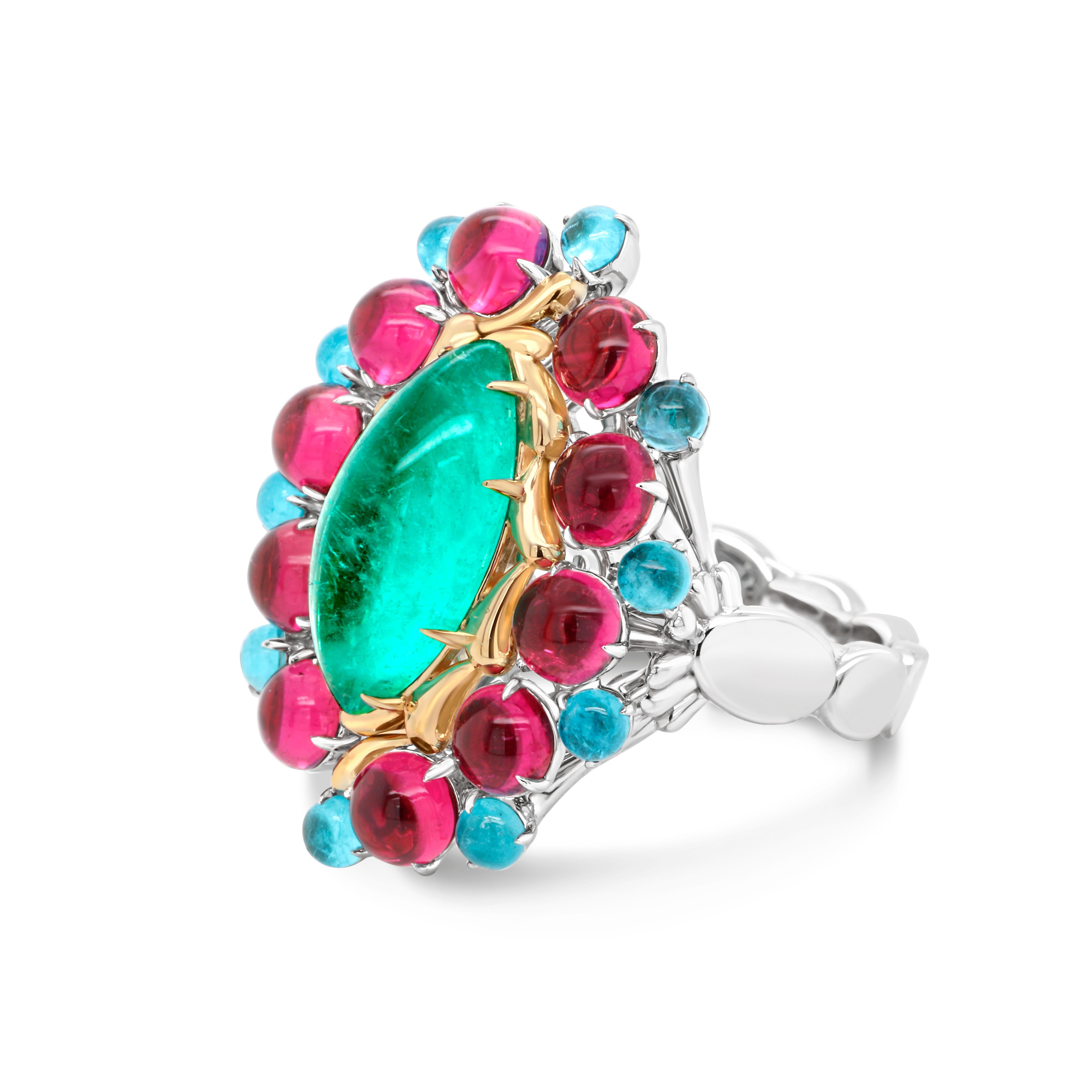 An exceptional splash of color that can intrigue your soul. 
18 KT Yellow and White Gold Ring. Center stone is a unique 3.0 ct top quality Russian Emerald AIGS Certified accented with marvelous round cabochons of Rubellites and Paraibas.
A real