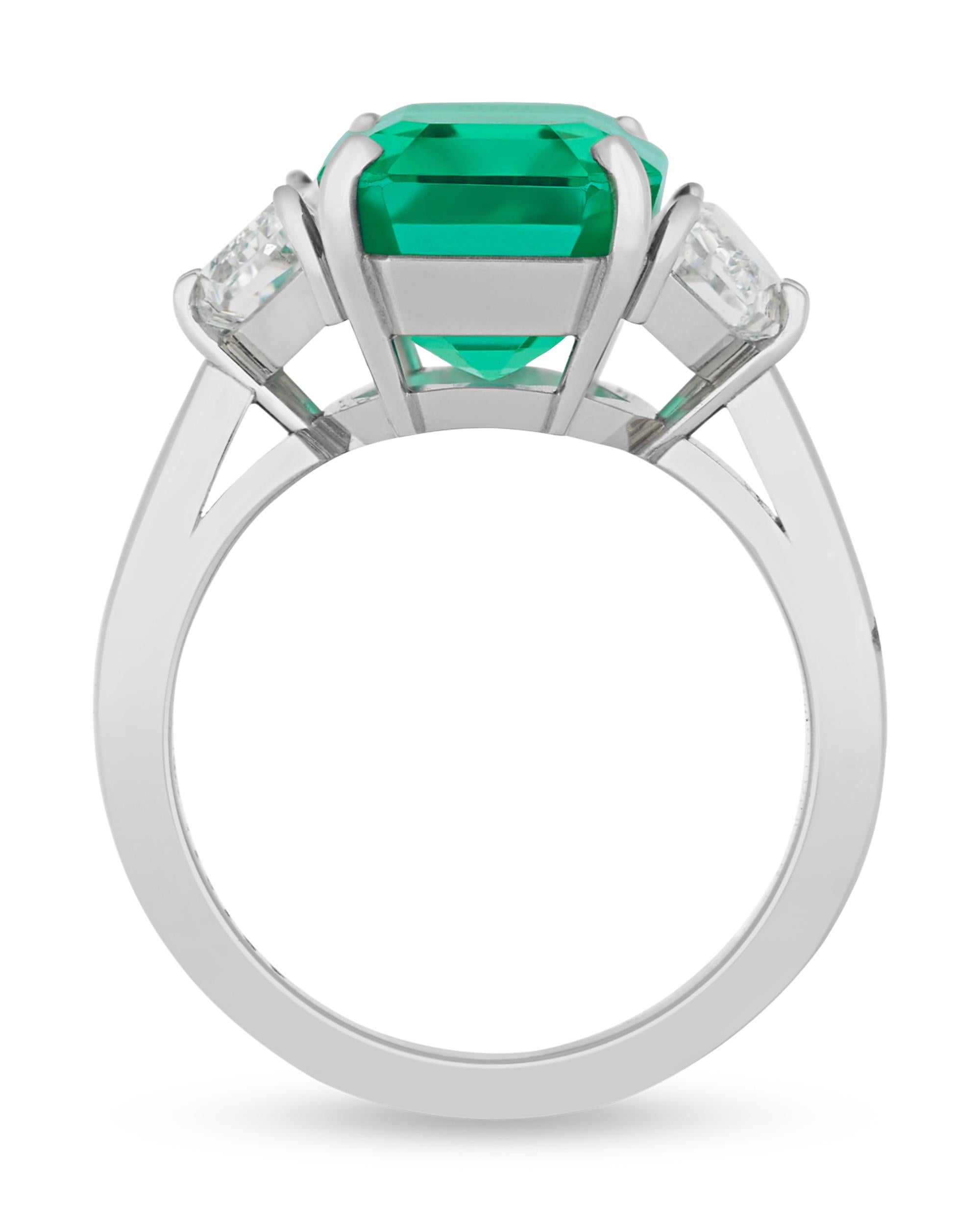 An exquisite and rare 7.16-carat Russian emerald centers this spectacular ring. A remarkable gemstone of unmatched quality, this emerald won the prestigious 