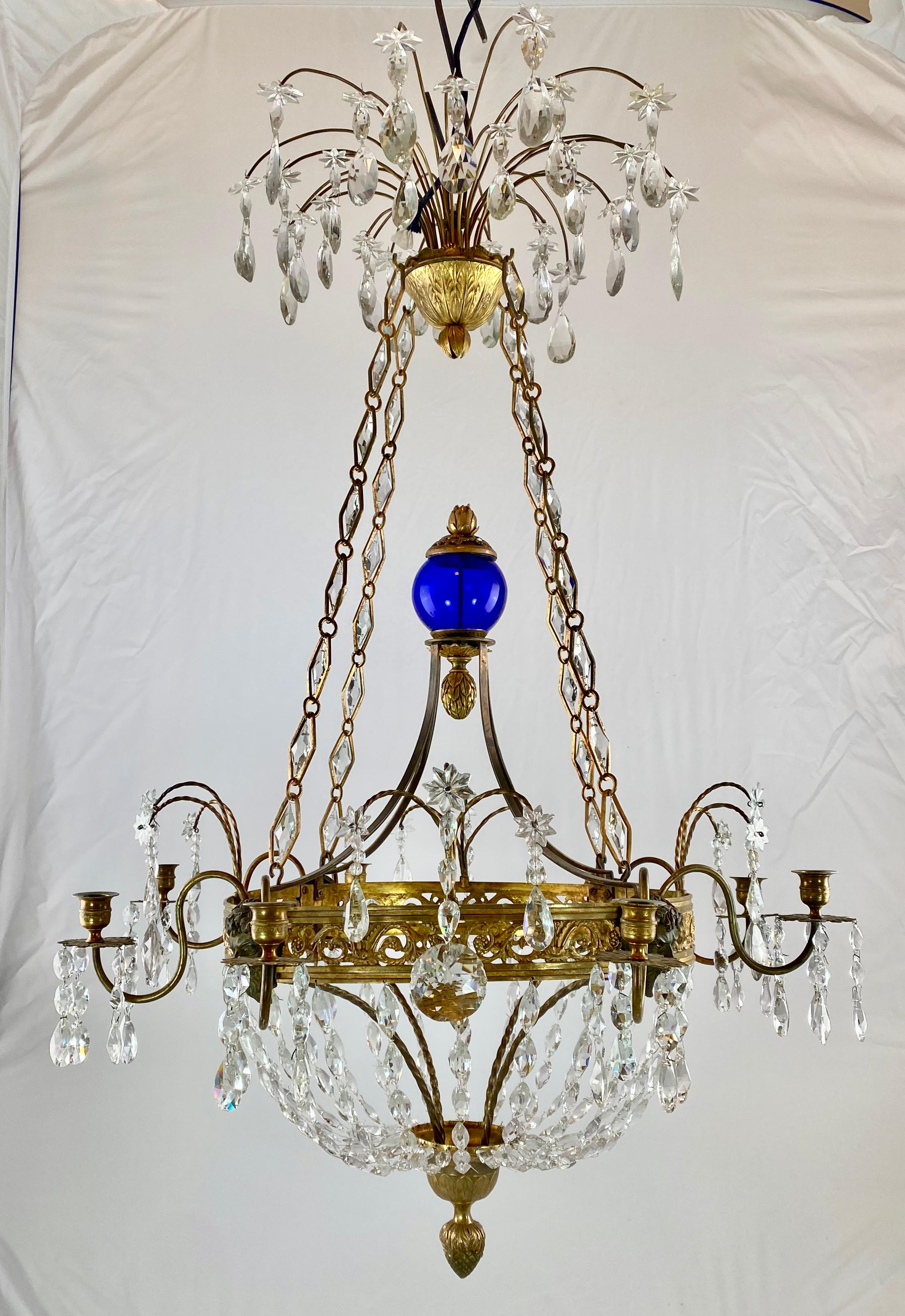 A Russian chandelier made in the early 19th c. Wonderful light design with large grotesque face masks on the ring holding the candlearms. The candleholders in shape of urns.
Everything made of either gilt or patinated bronze.