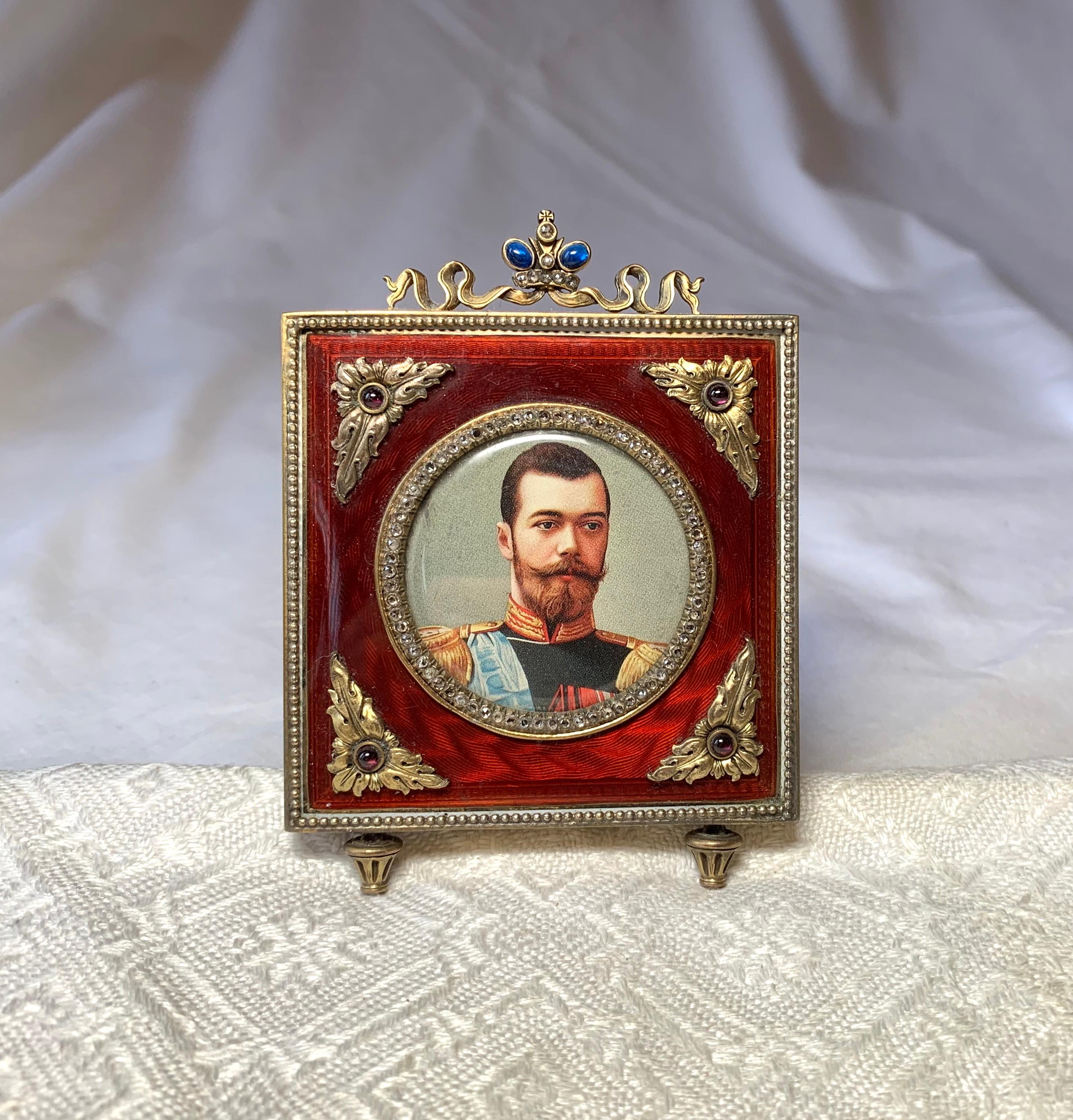 A stunning antique Russian Picture Frame decorated with Rose Cut Diamonds, Sapphires, Rubies and vivid red Guilloche Enamel.  The silver gilt frame is in the Faberge Style.  The small frame is a masterpiece of Russian Silver and Jewelry making.  It