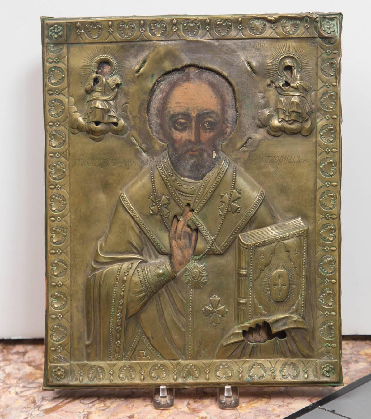 Brass covered icon on wood. Paintings within each cut out.
Highly detailed brass work,
Inscribed on the front, with what we believe to be Russian.
 