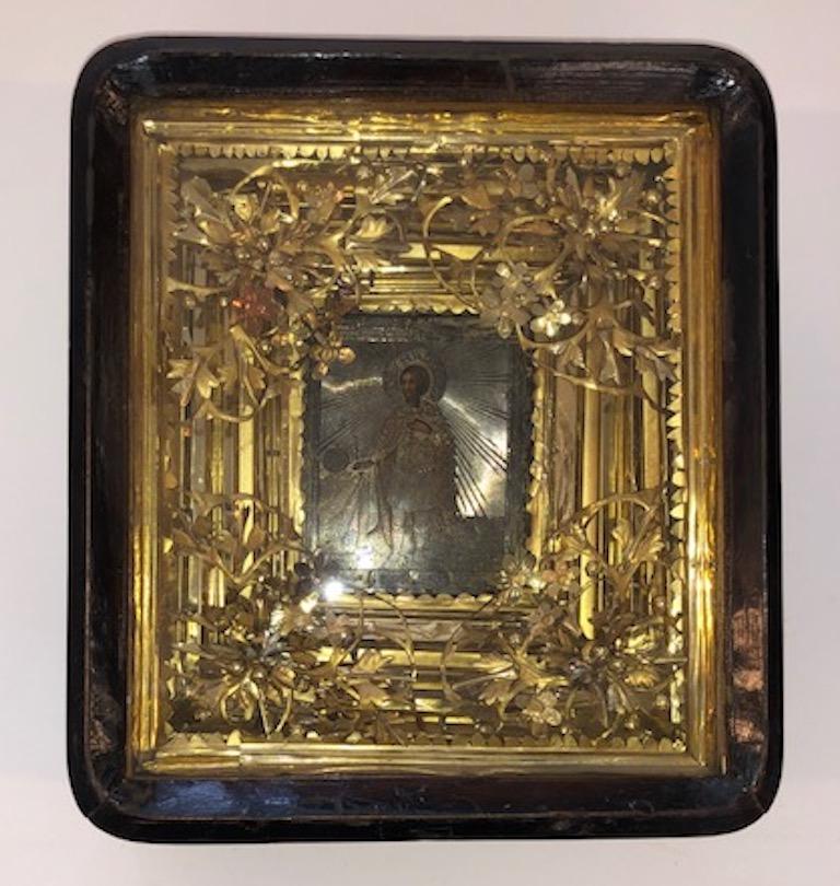 Russian Icon of Saint Alexander
Icon is done with oil paint on the wooden panel, embellished with silver oklad. It is placed in a wooden box (kiot) that is decorated with floral elements made out of gilded silver. 

 Russia, circa 1870s
3.5” W x