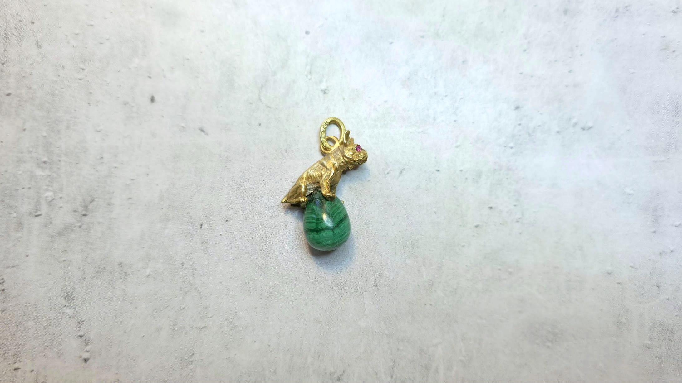 Nous présentons à votre attention une pièce unique et extraordinaire de notre collection - un pendentif en forme d'œuf en malachite orné d'une figurine de bouledogue en argent doré avec des yeux en rubis, créée à l'époque de Fabergé par le maître