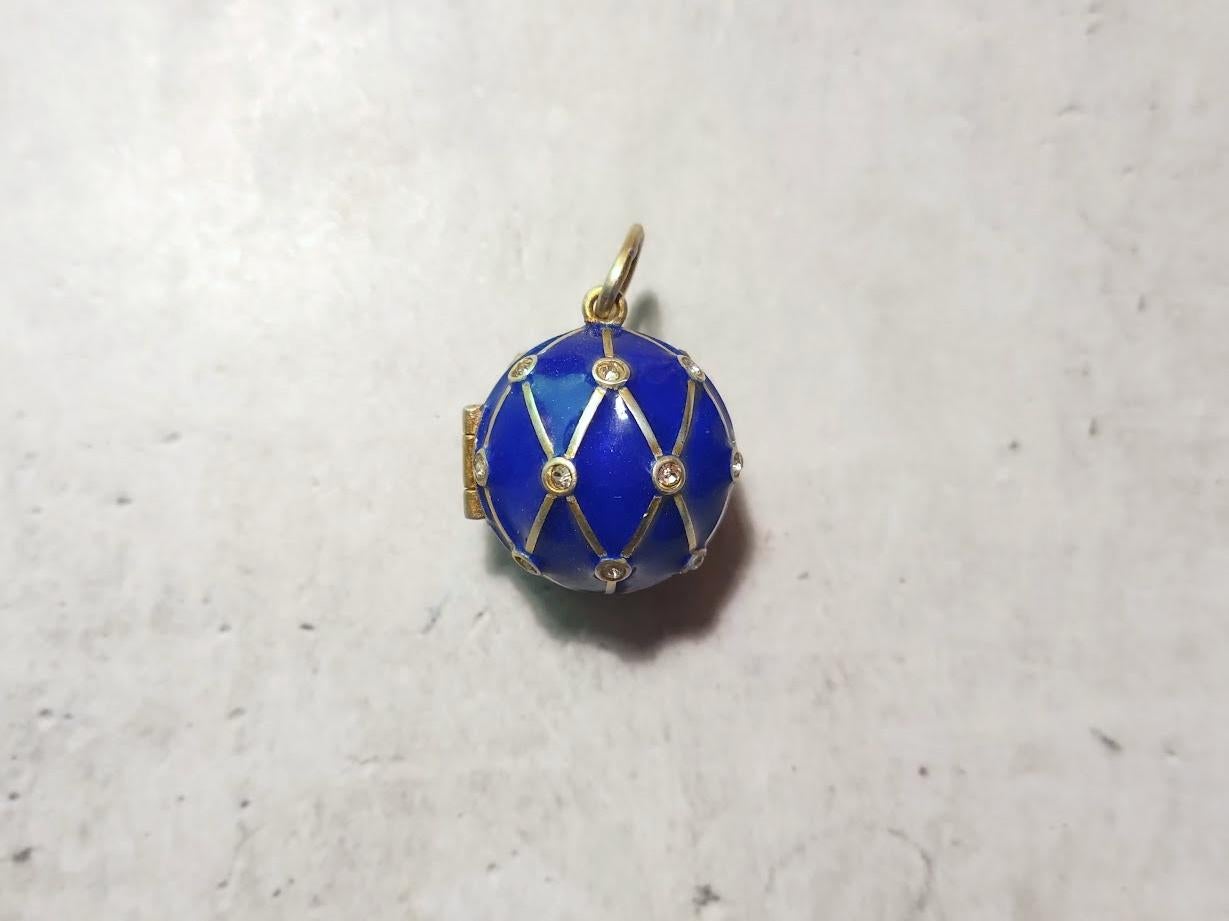 Ti presentiamo uno splendido ciondolo-medaglione a forma di palla imperiale russa dell'88 in argento dorato e smalto. Questo squisito pezzo presenta un'immagine in rilievo della maglia di cobalto con un diamante in pasta ornato da smalto oro e blu.
