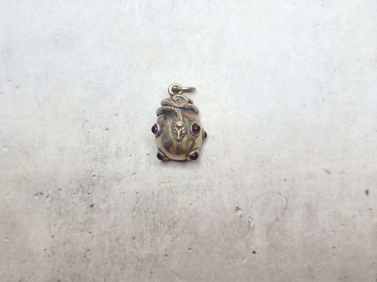 We are delighted to present an exquisite Imperial Russian gilt silver egg-shaped pendant. This elegant charm is adorned with a striking figural snake and seven deep red garnet cabochons.

The pendant measures approximately 26.6 mm in length and 18