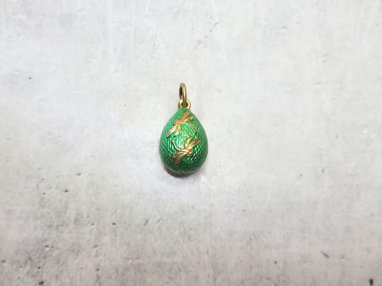 This Fabergé pendant, a rare and historically significant piece, was crafted by the renowned workmaster Phillip Theodore Ringe. This silver gilded egg is covered in stunning green guilloche enamel and adorned with two charming dragonflies.
Its