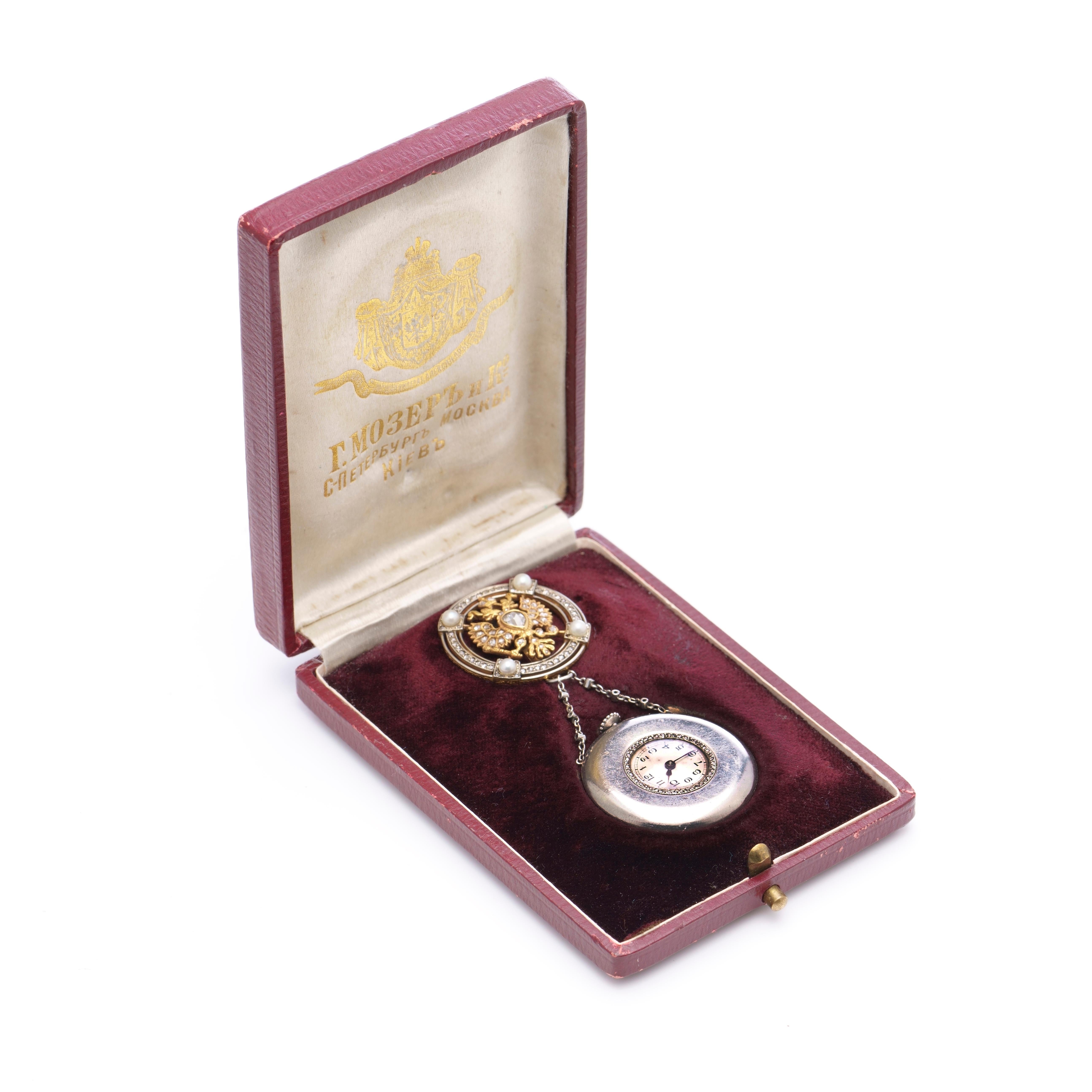 Russian Imperial presentation jewelled platinum and gold pendant watch
Made by Moser & Co
Made in St. Petersburg, 1908-1917

The circular brooch centered with a gold, gem-set Imperial double-headed eagle within a border set with diamonds and pearls,
