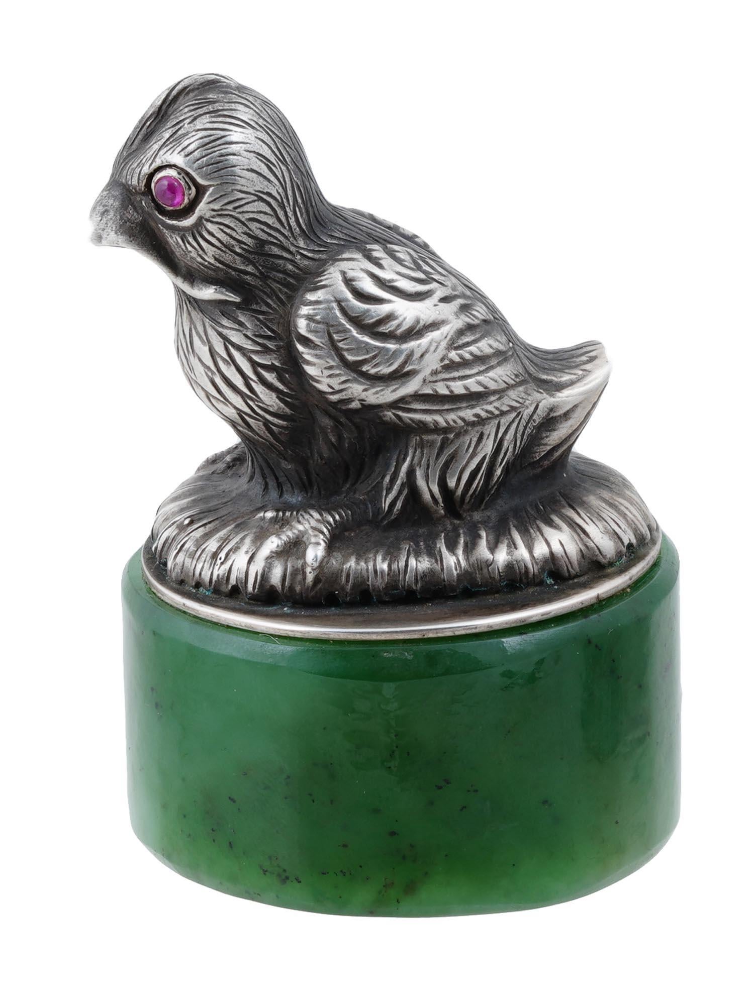 Ti presentiamo un'esclusiva statuetta d'argento in miniatura da collezione a forma di uccello con occhi di rubino su un supporto in nefrite naturale russa. Russia, Mosca, 6° Artel di Mosca, 1908-1917.

Punzoni: campione imperiale d'argento 84 con