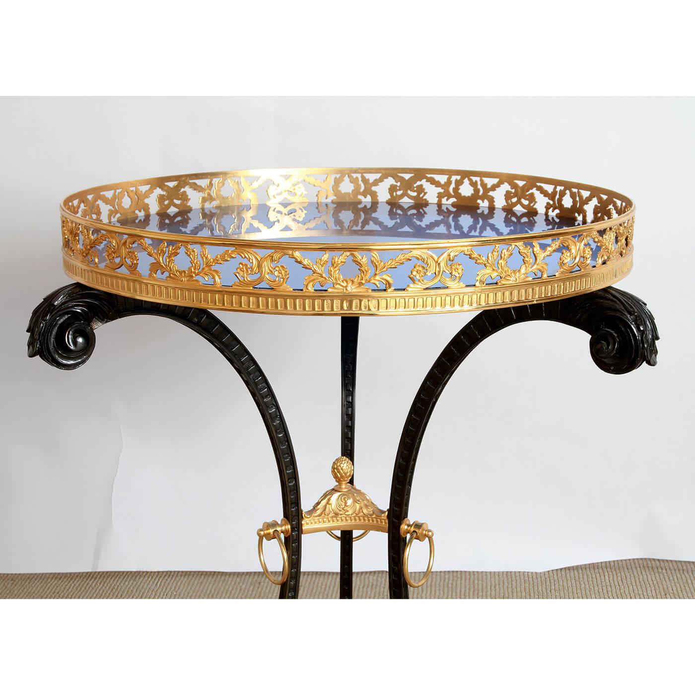 An unusual Russin Neo-Classic style bronze Gueridon with an ormolu pierced bronze gallery, a transparent cobalt glass circular table top, with a patented bronze scrolling legs centered by an ormolu bronze acanthus and acorn stretcher. 20th