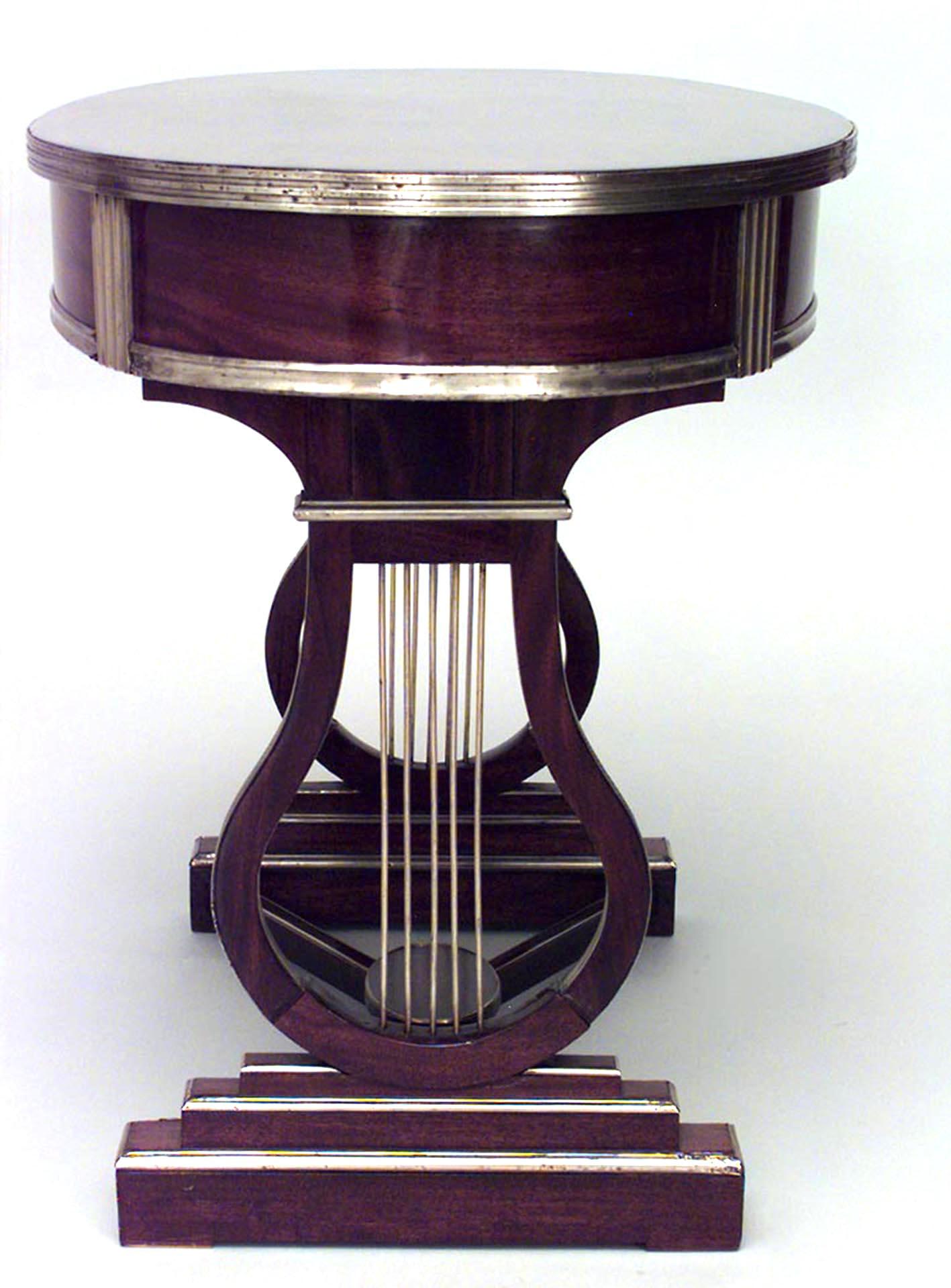 Table à écrire russe néoclassique (18/19e siècle) en acajou monté sur laiton, avec un plateau ovale au-dessus d'un tiroir en frise sur des supports en tréteaux en forme de lyre reliés par une entretoise.
