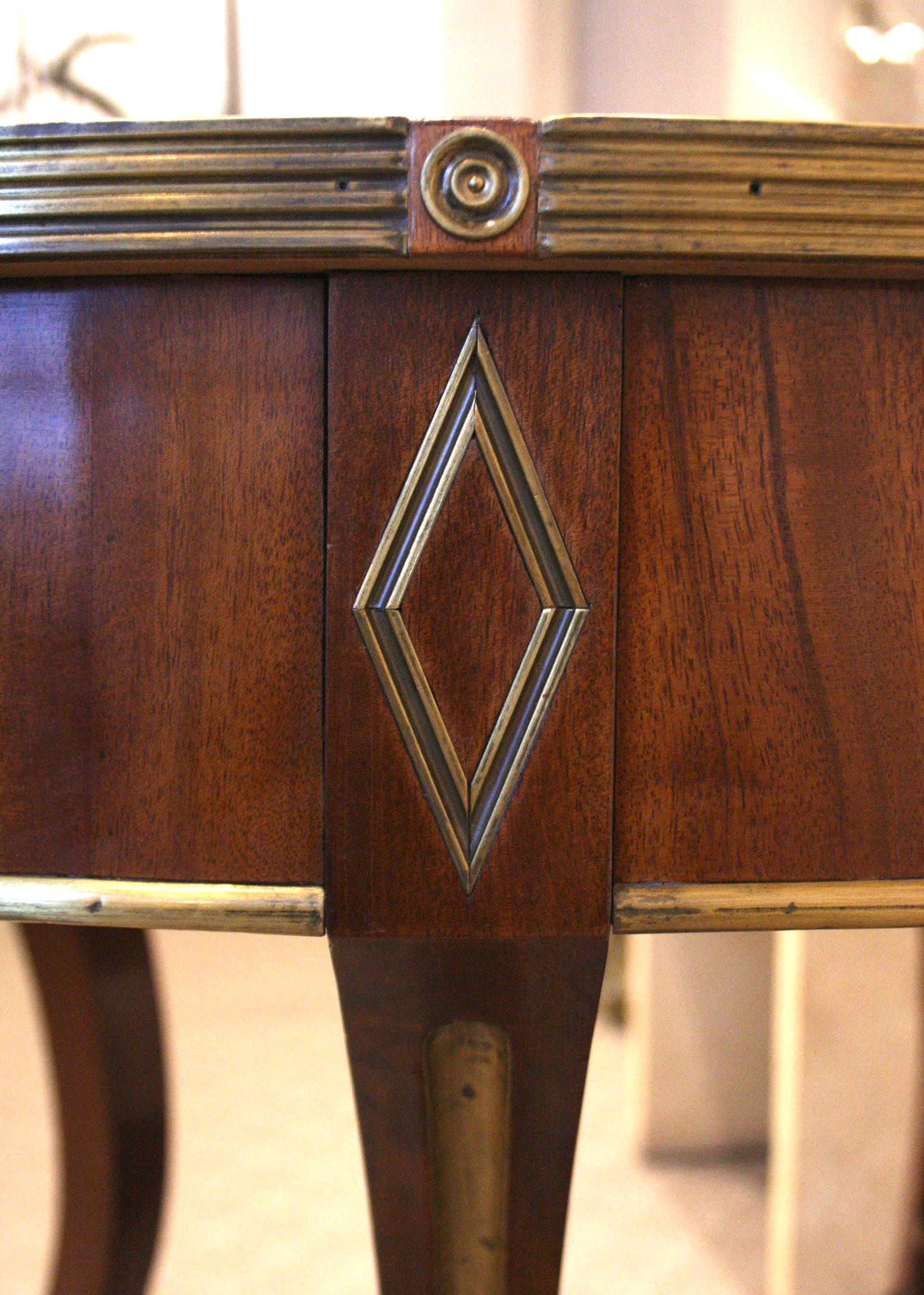 Russian Neoclassic (18/19th Century) brass mounted mahogany center table with an oval top over an apron with central drawer. Supported by 4 exaggerated 