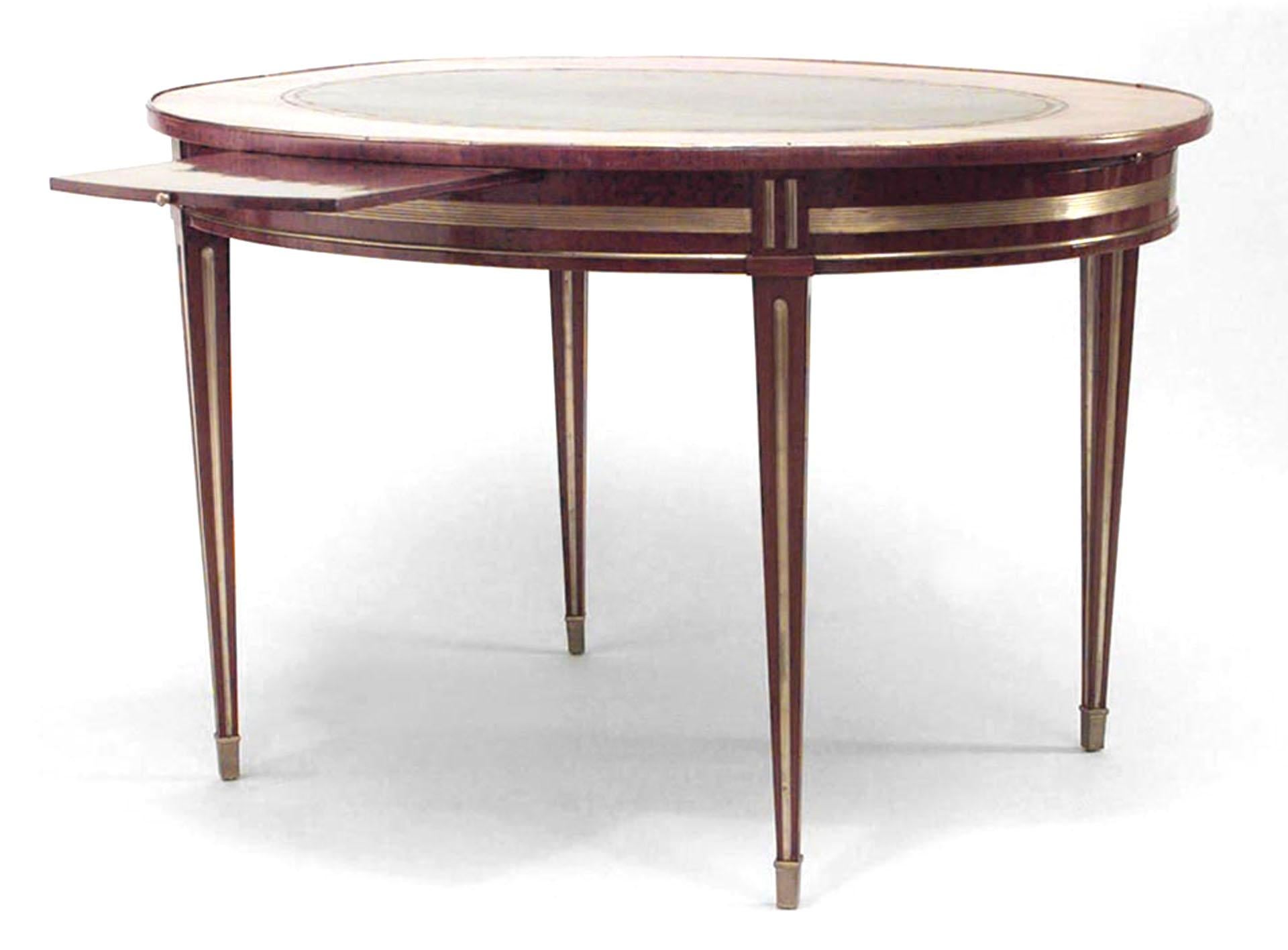 Russian Neoclassic (late 18th/early 19th Century) brass mounted mahogany center table with tulipwood banded black leather inset oval top over 4 slides on fluted legs.

