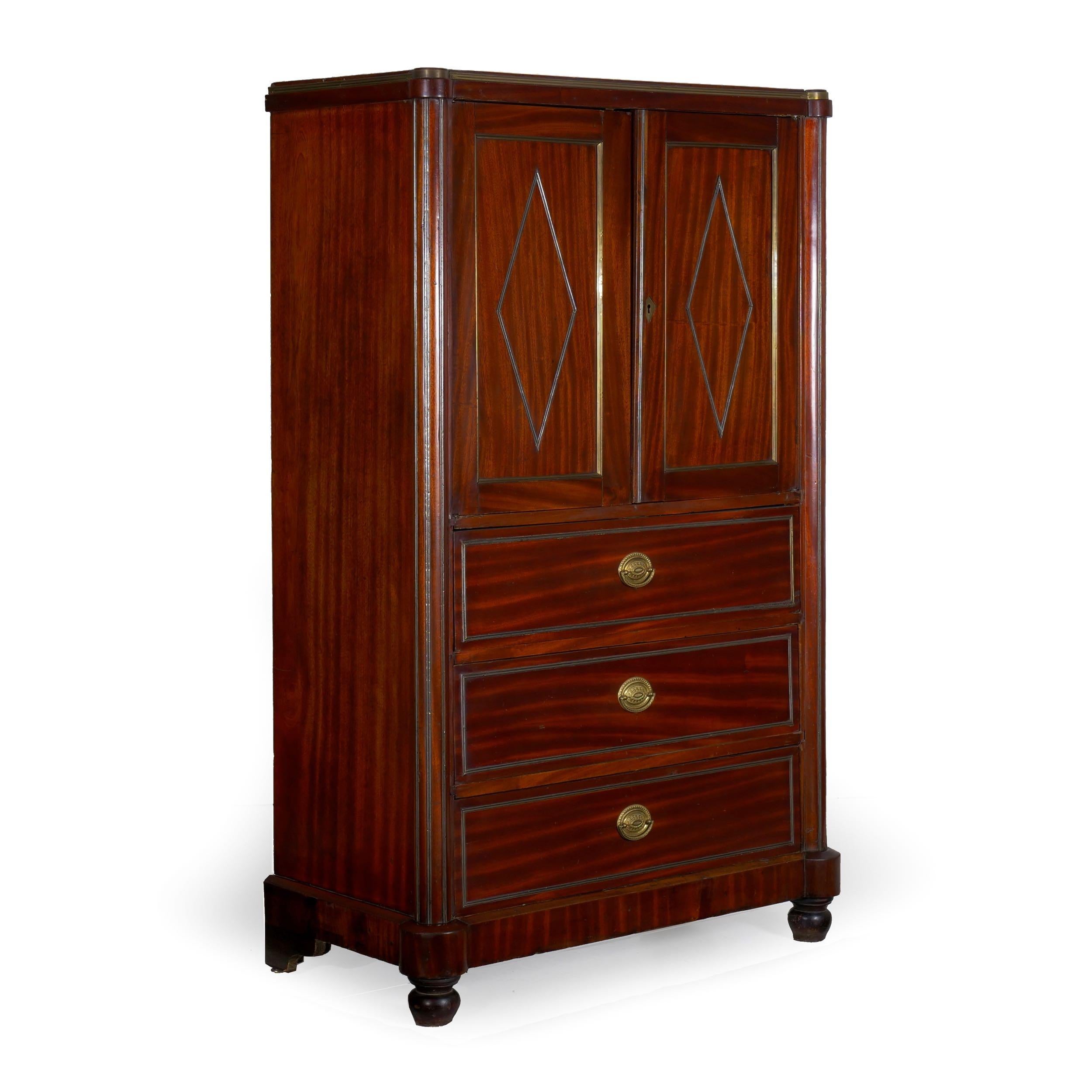 An interesting cabinet with a dense Cuban mahogany veneer, the armoire is likely of Russian origin in light of the early latch hardware in the left door marked with cold-stamped Cyrillic.

The open cabinet is situated over three drawers, each hand