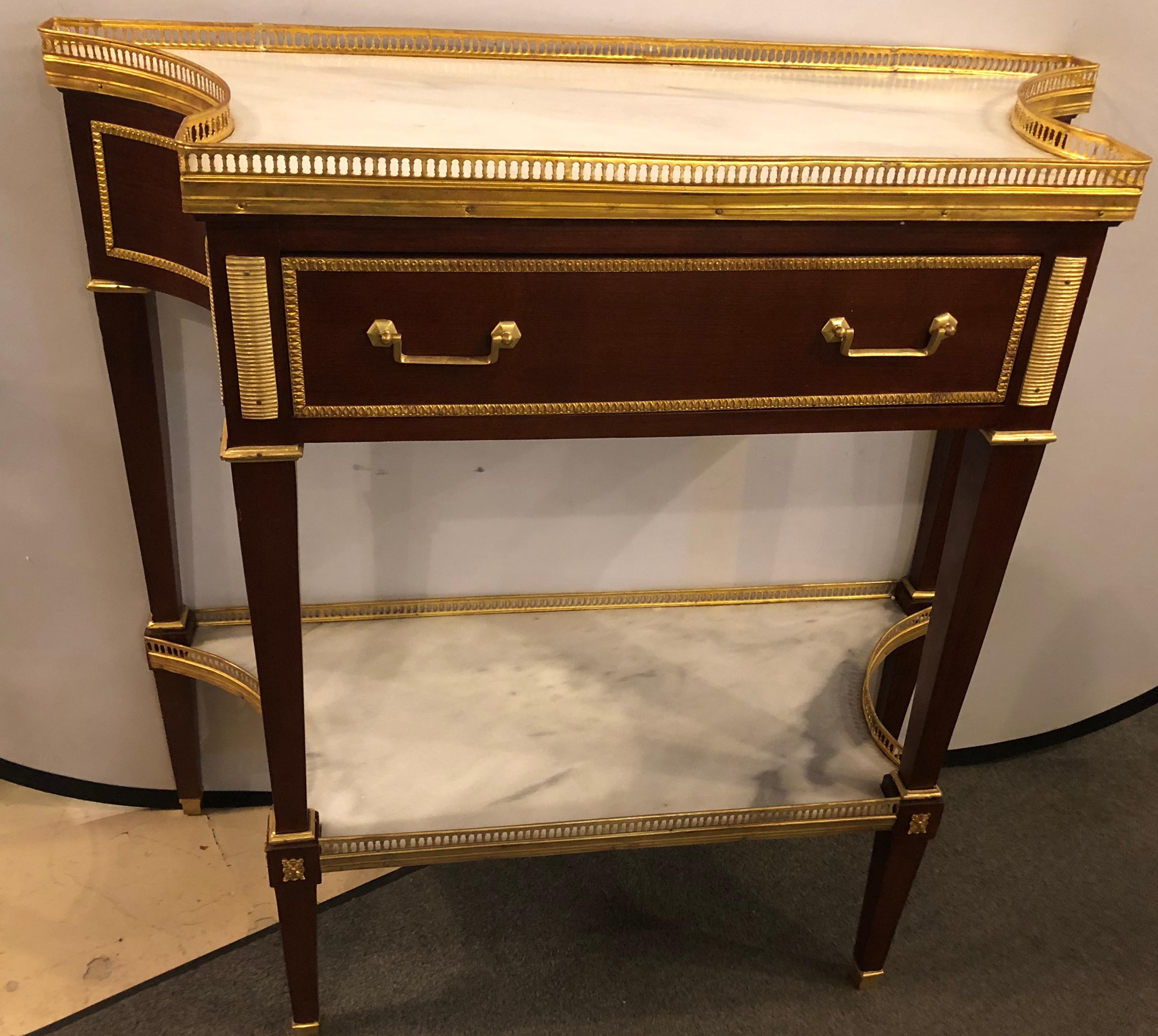 Russian neoclassical style console with inverted sides and marble top. This fine Maison Jansen inspired console tables or serving tables depict the glamour of the Hollywood Regency era at its height. Having tapering legs with bronze mounts leading