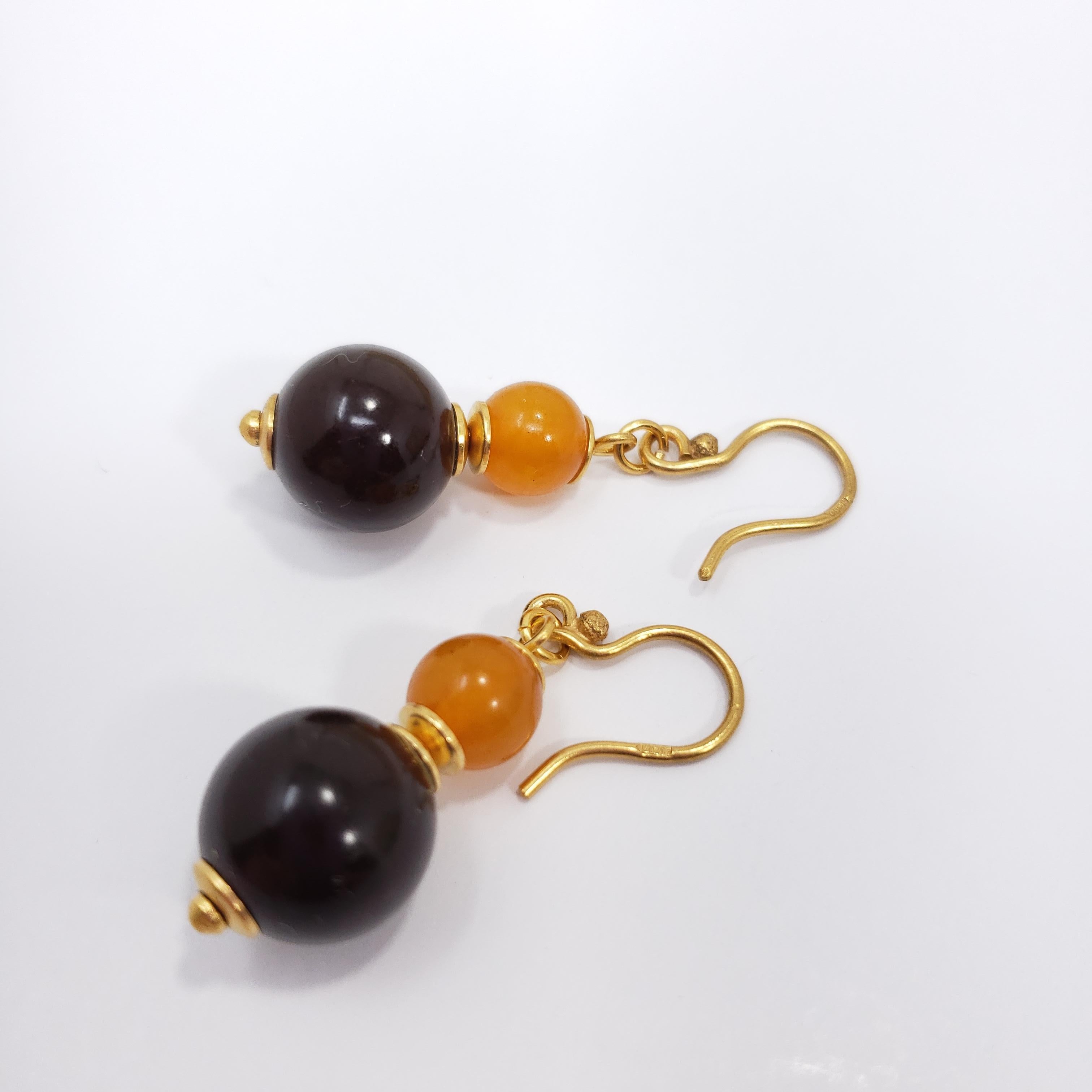Une paire de boucles d'oreilles russes exquises. Chaque boucle d'oreille comporte deux perles d'ambre baltique aux riches couleurs orange et marron, rehaussées d'accents et de crochets en pierre dorée. Un style à part entière !

Poinçons : Marques