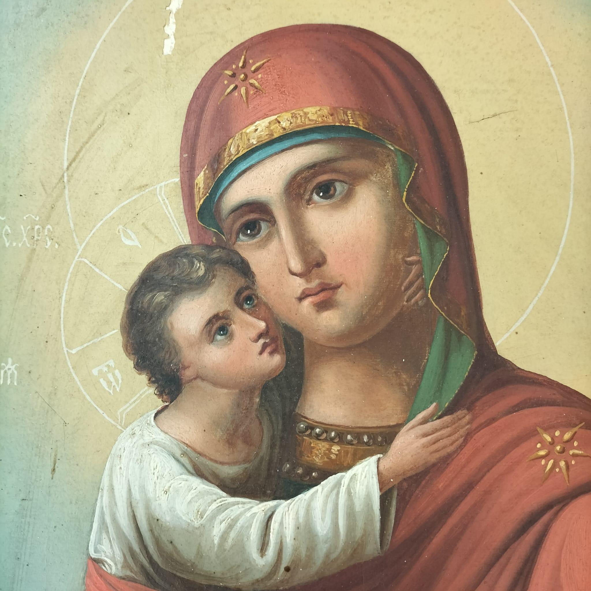 This is a traditional Russian Orthodox icon of the Virgin Mary, holding the Christ child close to her face in an embrace. Both figures have delicate halos surrounding their heads, with inscriptions in Cyrillic by their sides. The Virgin Mary is