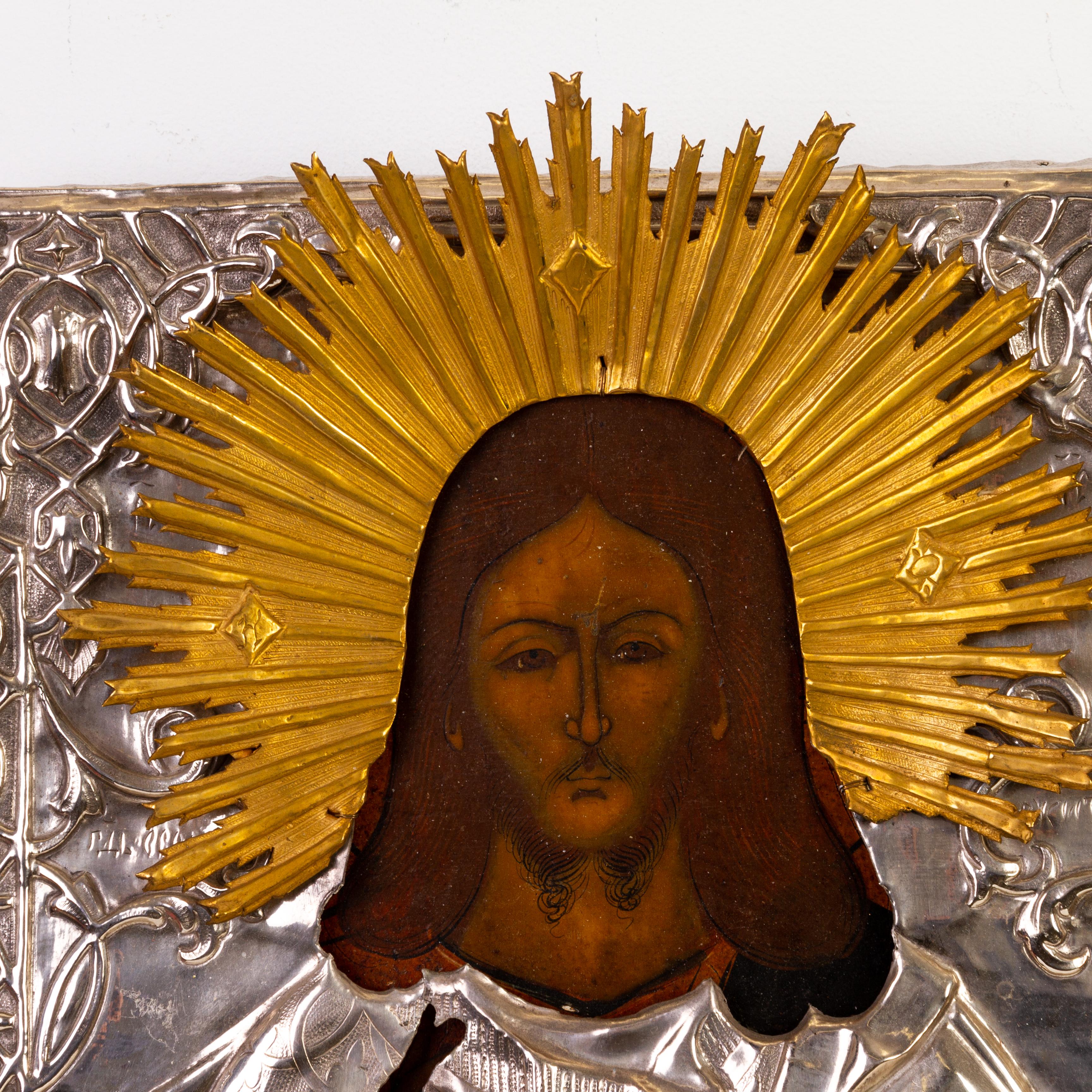 This remarkable 19th-century Russian Orthodox polychrome wood panel icon of Christ is a stunning example of religious artistry and craftsmanship. The icon features vibrant colors and intricate detailing, reflecting the deep spiritual and cultural
