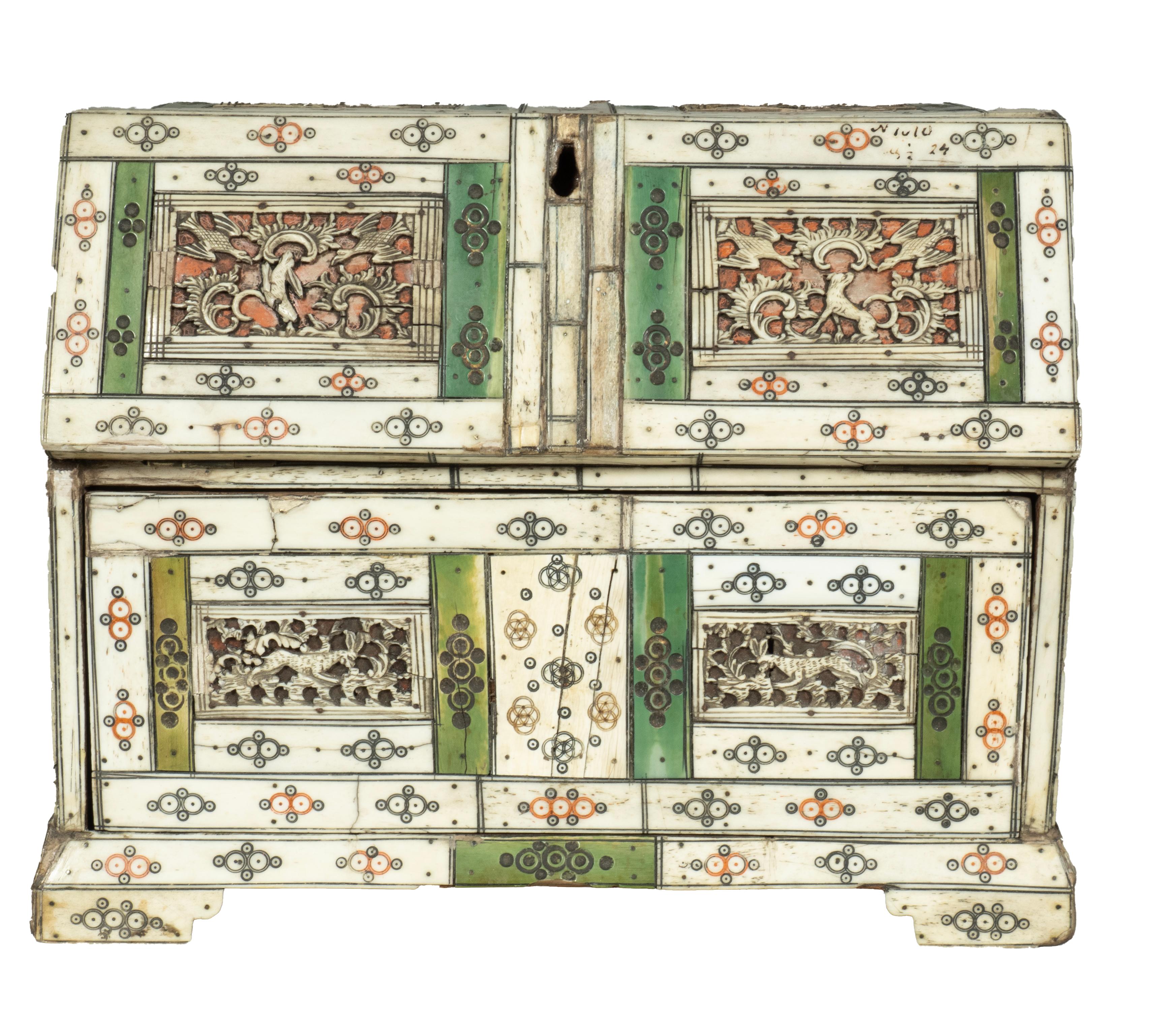 Made as a slant lid desk with fold down writing lid opening to a fitted interior. Two drawers below and bracket feet. Bone is white and tinted green. Carved details.