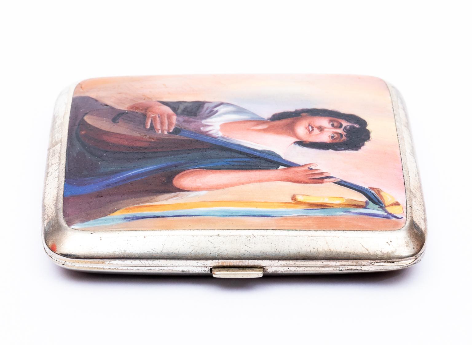 Circa 1900-1940s antique Russian silver and enamel cigarette case. The piece is solidly made and features hand painted enamel depicting a young girl playing on a guitar on the exterior and a gilded interior. The case is also marked with a woman's