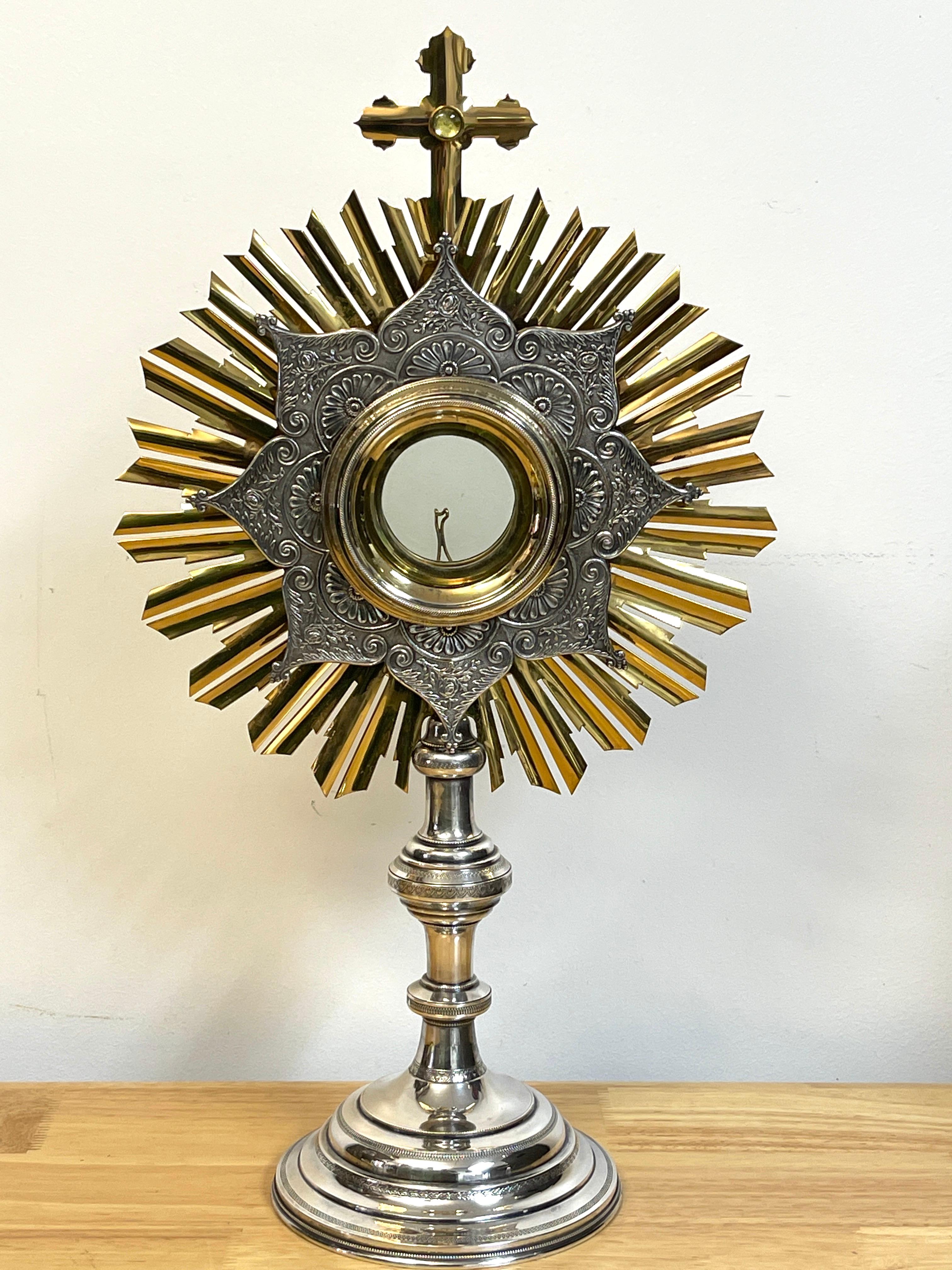 Russian silver & gilt bronze monstrance /reliquary, with a jewel set Cross atop a gilt bronze sunburst with inset repouse silver interior, revealing the removable crystal Luna. Raised on engine turned Russian Silver 864 pedestal base. Stamped '864'.