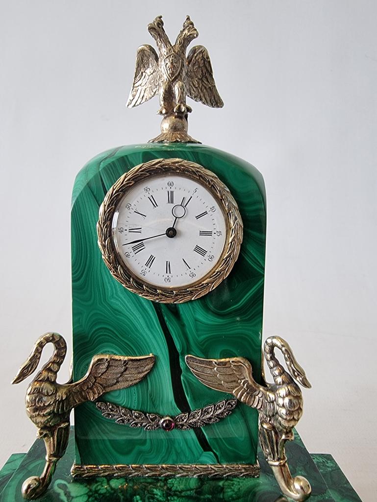 An early 20th century Russian malachite, diamond and silver gilt desk clock. .84 silver gilt content and Moscow Second Kokosnik mark (1908-26). Fine white enamel dial with roman numerals and outer minutes in arabic numerals with blued steel hands.