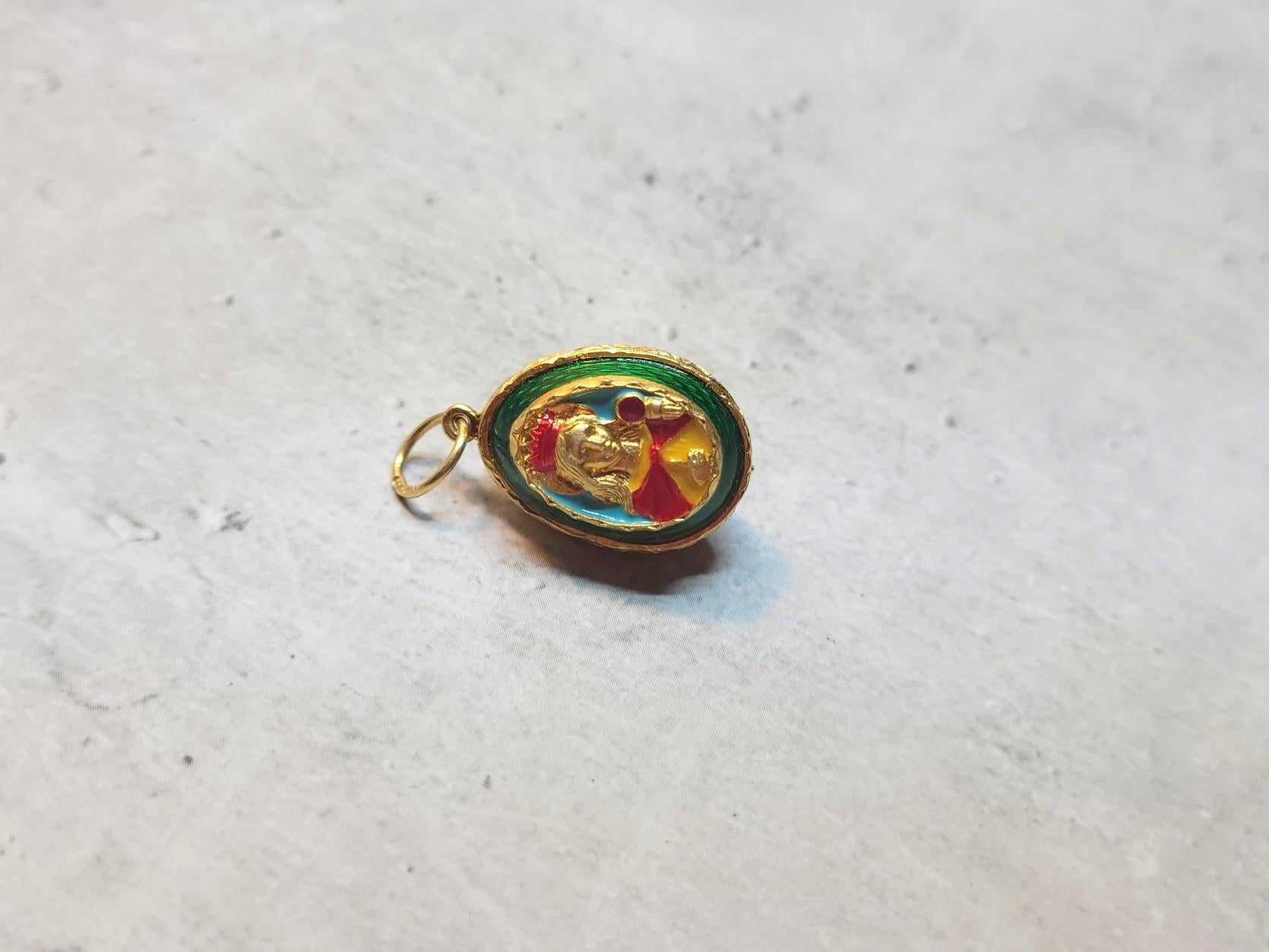 Presenting a stunning pendant designed in the shape of a Russian Imperial 84 gilt silver and enamel egg. This exquisite piece showcases a relief image of the Mother of God, adorned with gold and Guilloche enamel, displaying a captivating emerald