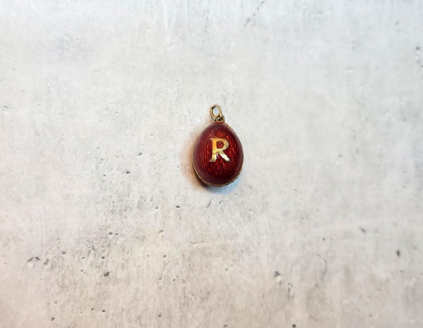 Presenting a stunning pendant designed in the shape of a Russian Imperial gilt silver and enamel egg. The body of the egg is enameled in a deep, beautiful red guilloche enamel. The repeating patterns of the enamel look like hundreds of sun rays