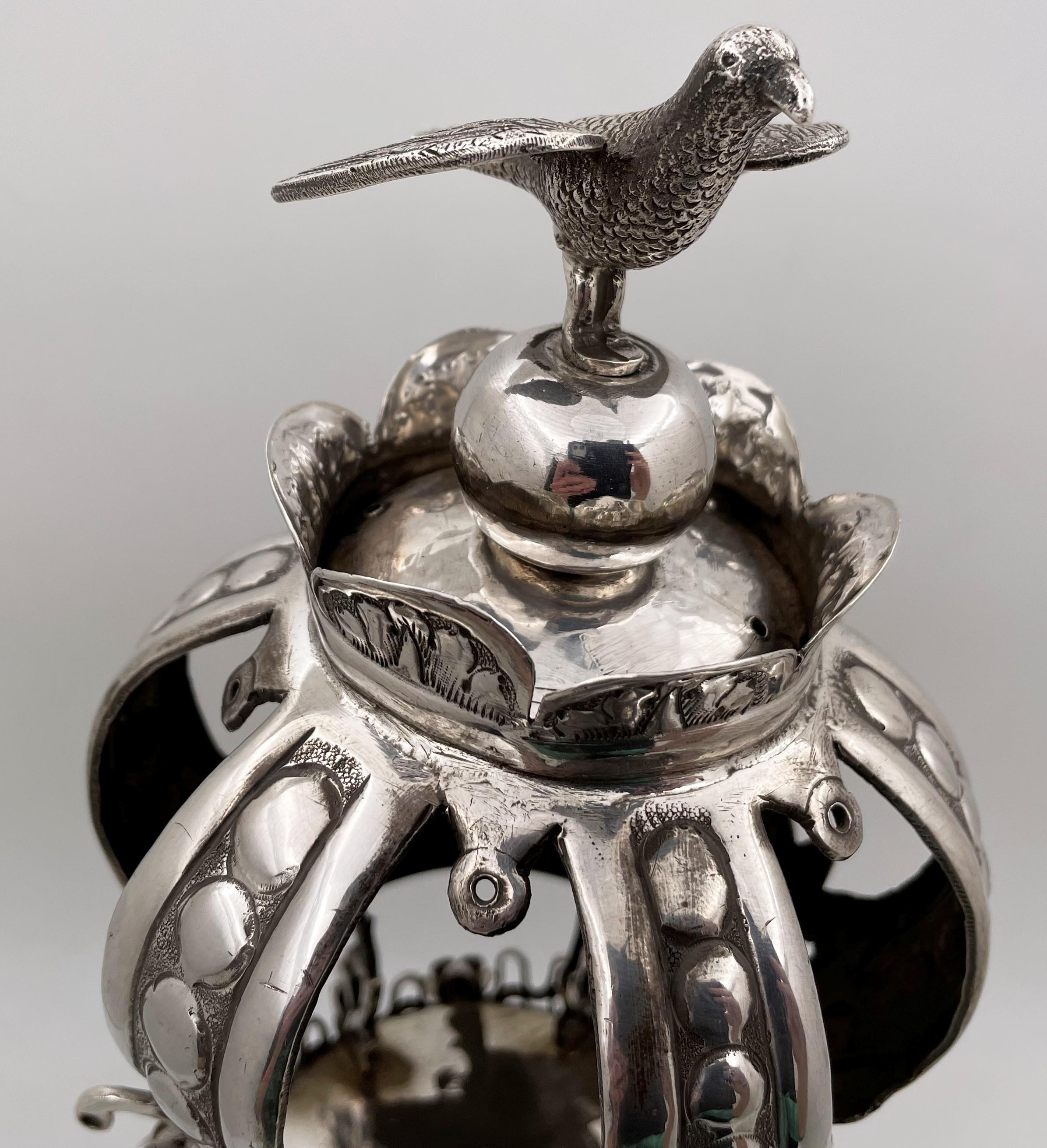 Russian, sterling silver Torah crown, topped with a bird, from the turn of the century, all beautifully detailed with flowers and animal motifs, with Hebrew and English inscriptions. It measures 20 1/4'' in height by 8'' in diameter, weighs 86 troy