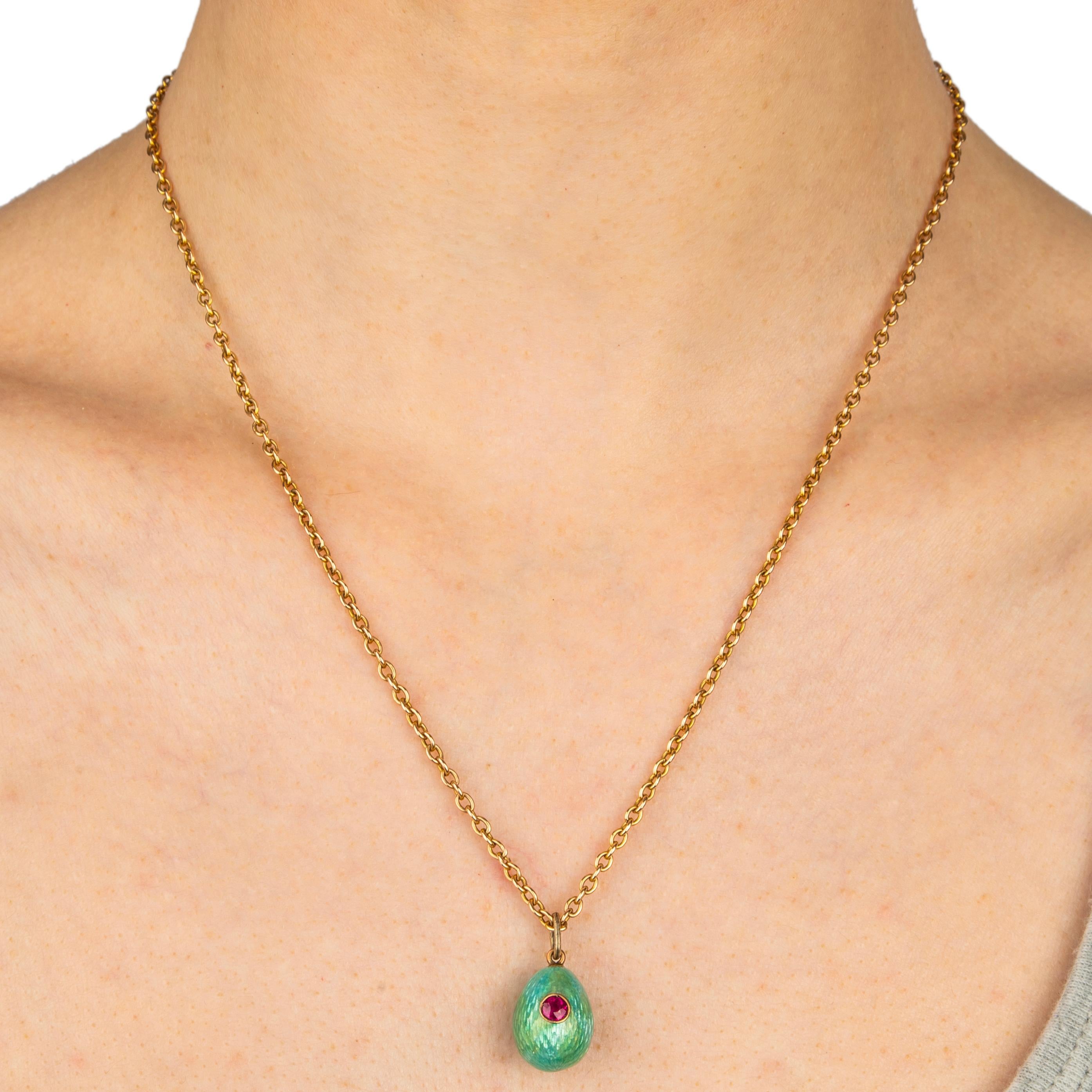 From the Romanov era, period of Tsar Nicholas II, a rare Russian teal blue guilloché enameled miniature egg pendant (enamel repaired) enhanced with a circular-cut ruby bead set in a silver bezel, fitted with a gold suspension ring. 

circa 1900

7/8