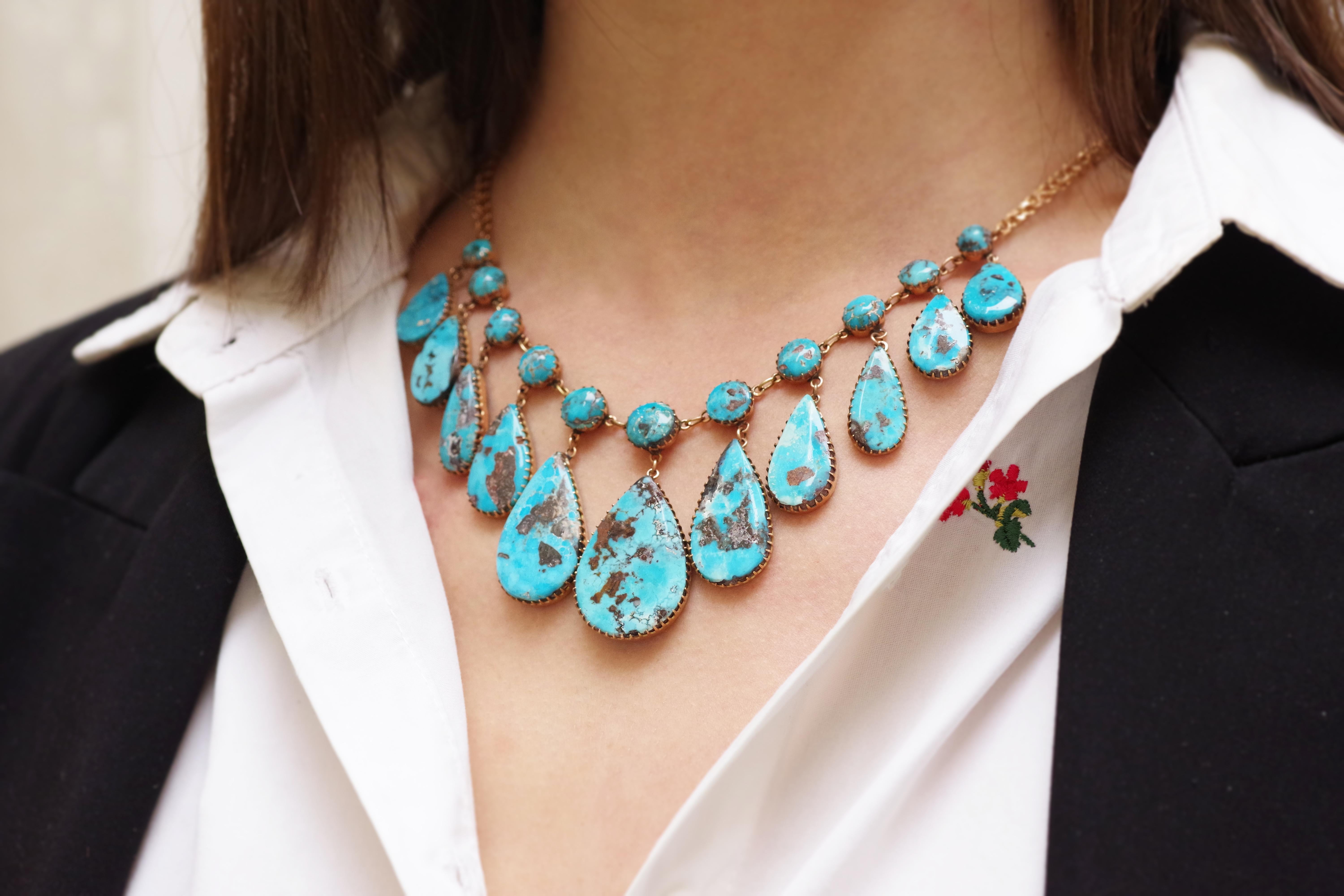 Russian turquoise drapery necklace in 14 karat rose gold. Drapery necklace composed of eleven drop-shaped plates topped with turquoise cabochons. The turquoise is a beautiful lagoon blue with natural brown inclusions (pyrites and matrix). The