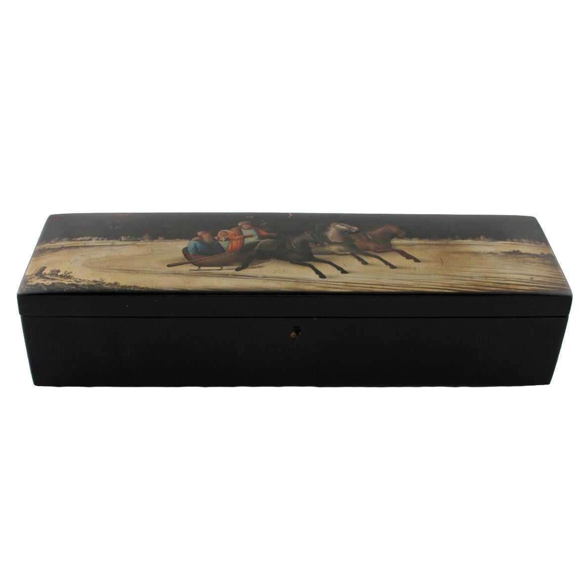 A late 19th century Russian black lacquered box by Vishniakov.

The long oblong shaped lid is decorated with a winter scene of a Russian troika being pulled through the snow by three horses.

The lid has a long metal hinge and inside is red