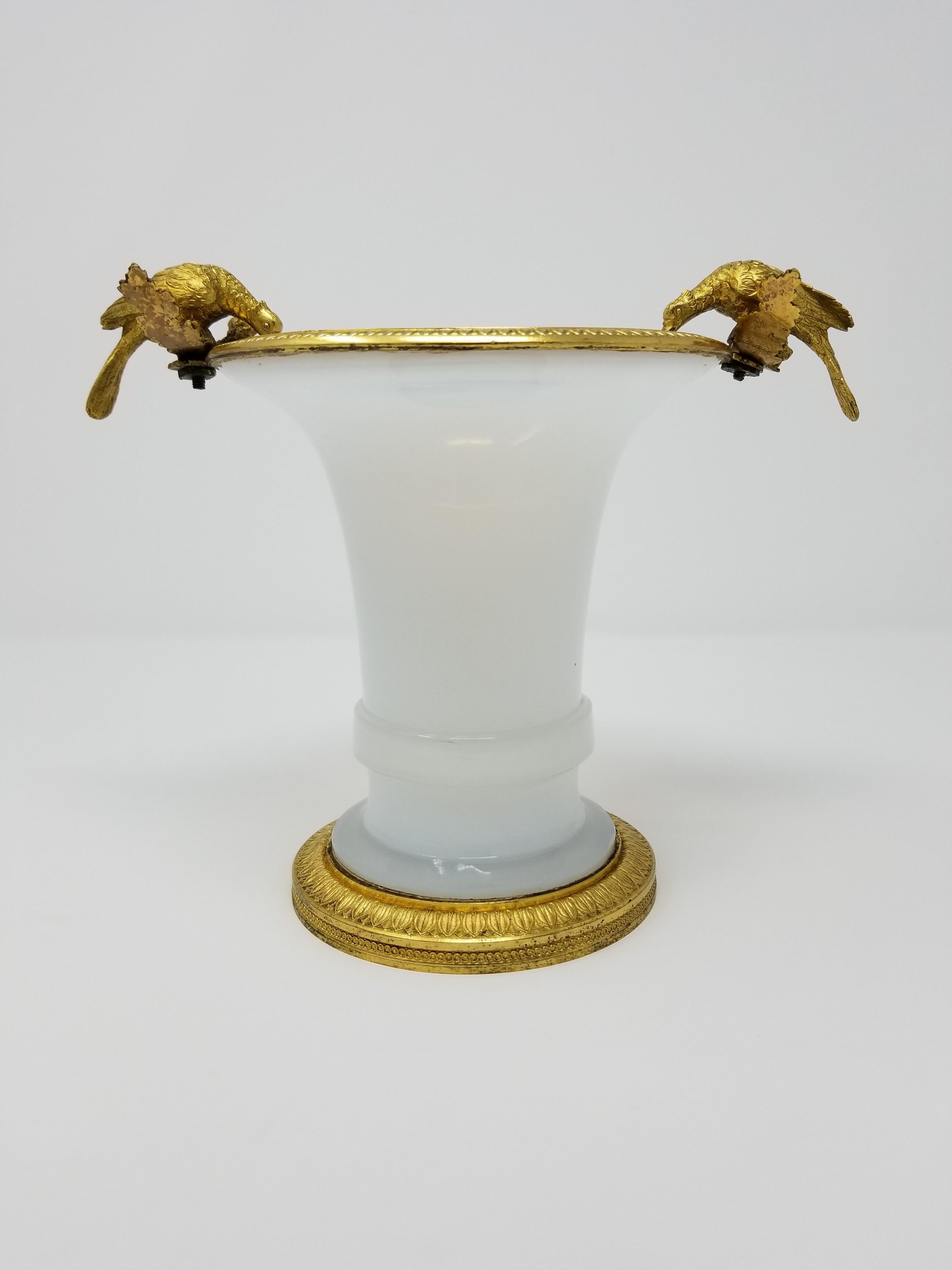 A fabulous Russian Empire/Louis XVI style white transparent opaline and ormolu-mounted vase/centerpiece, attributed to the Imperial Russian Glass Manufactory, from the estate of Peggy and David Rockefeller. Surmounted on top are two beautifully