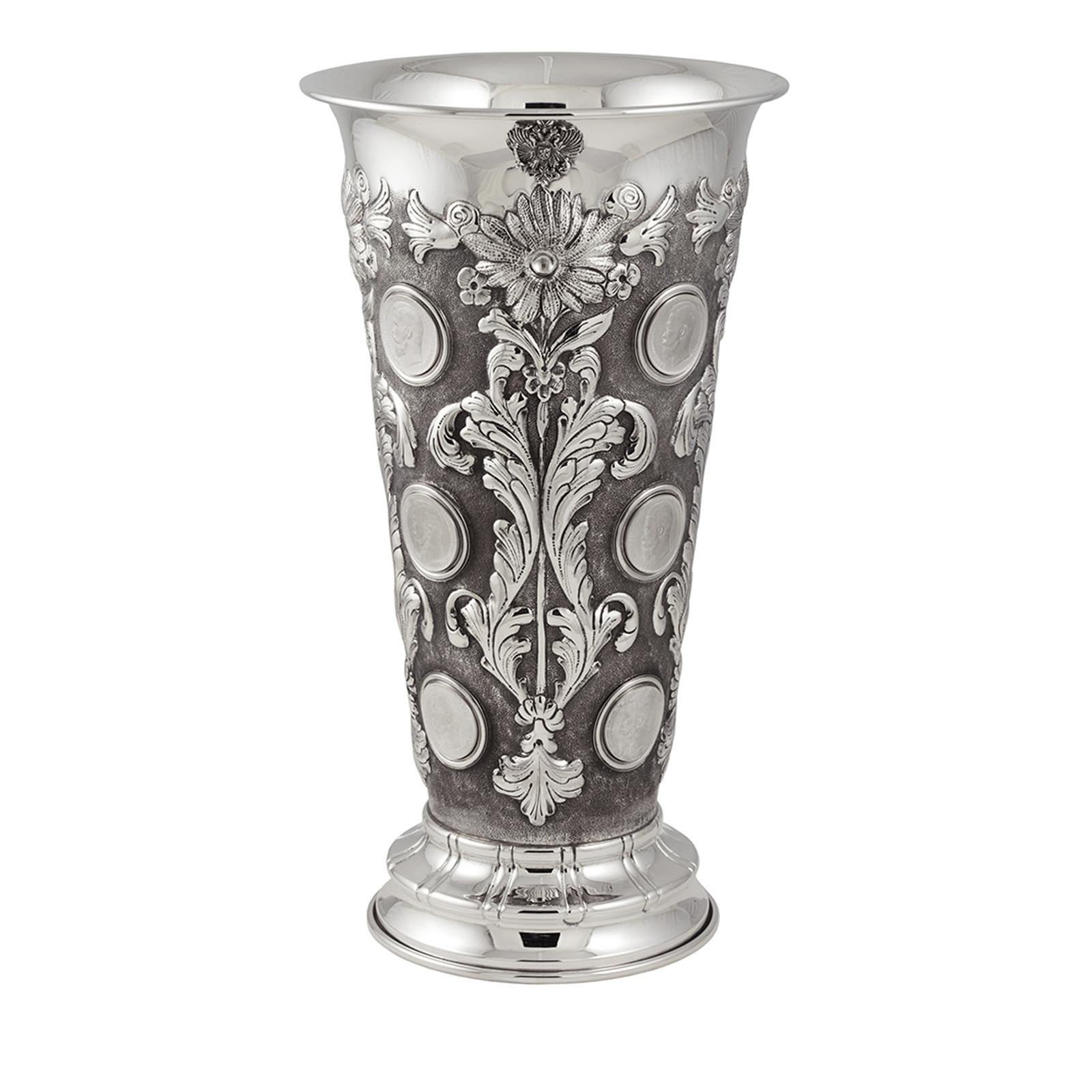 This magnificent vase is made entirely in silver and inspired by the Russian style. The conic, simple shape of the vase rests on a small plinth and is adorned throughout with twelve coin-like bas-relief decorations depicting the profile of Tzar