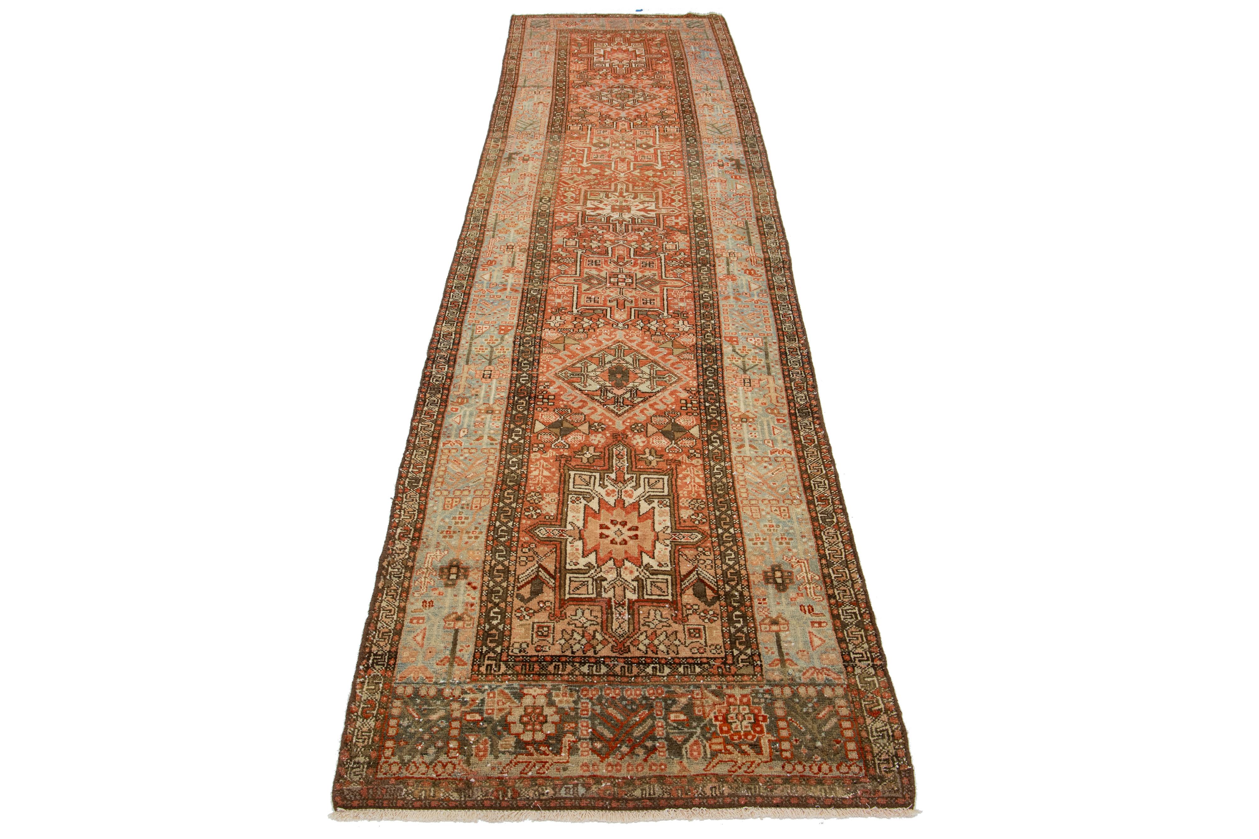 This beautiful 20th-century Heriz hand-knotted wool runner has a rust-colored field. The piece features stunning blue and brown accents in a gorgeous tribal design.

This rug measures 3'4