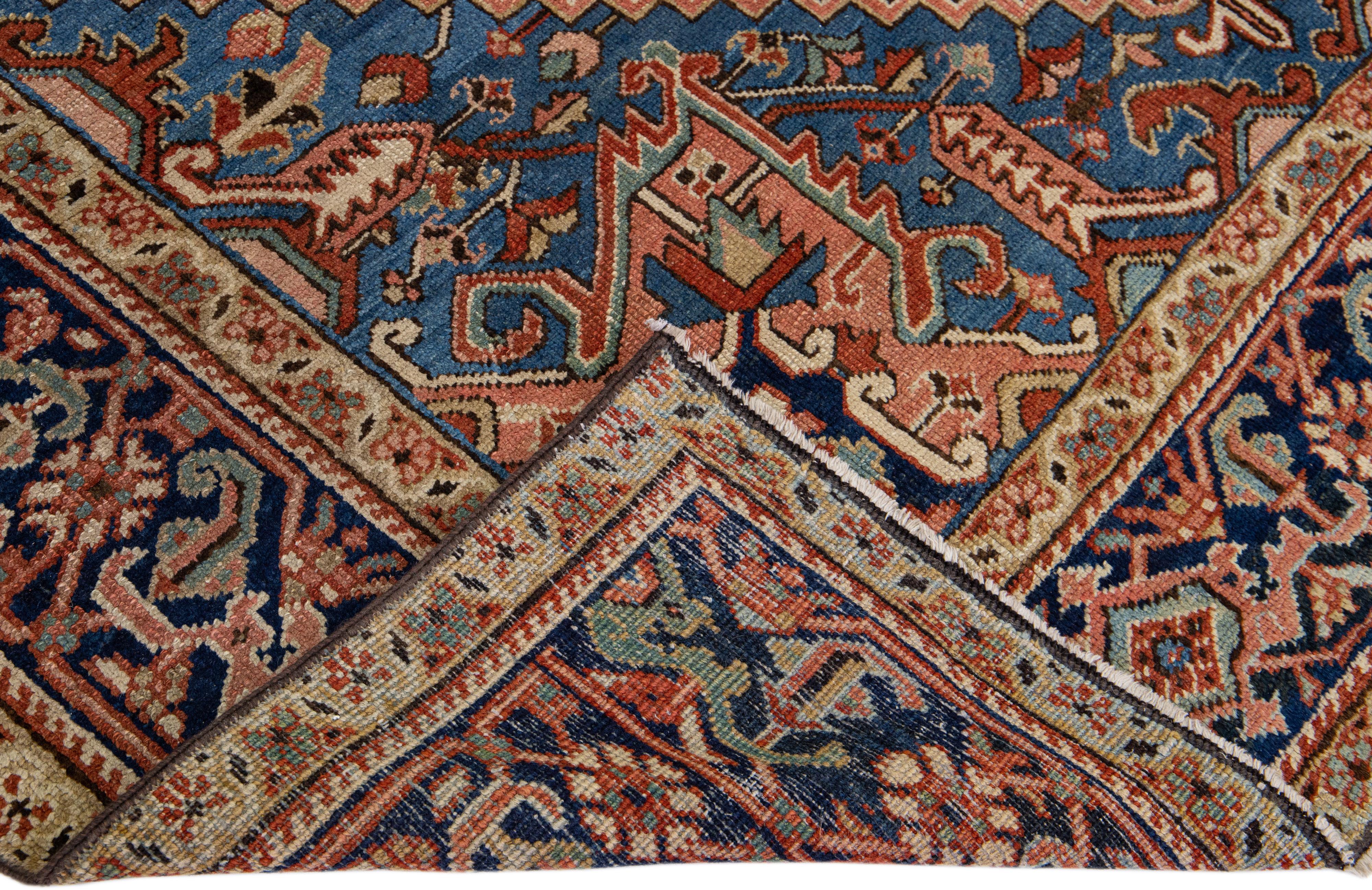 Beautiful antique Heriz hand-knotted wool rug with a rust field. This Heriz rug has a navy blue frame and multi-color accents in a gorgeous all-over Medallion floral design.

This rug measures: 7'8