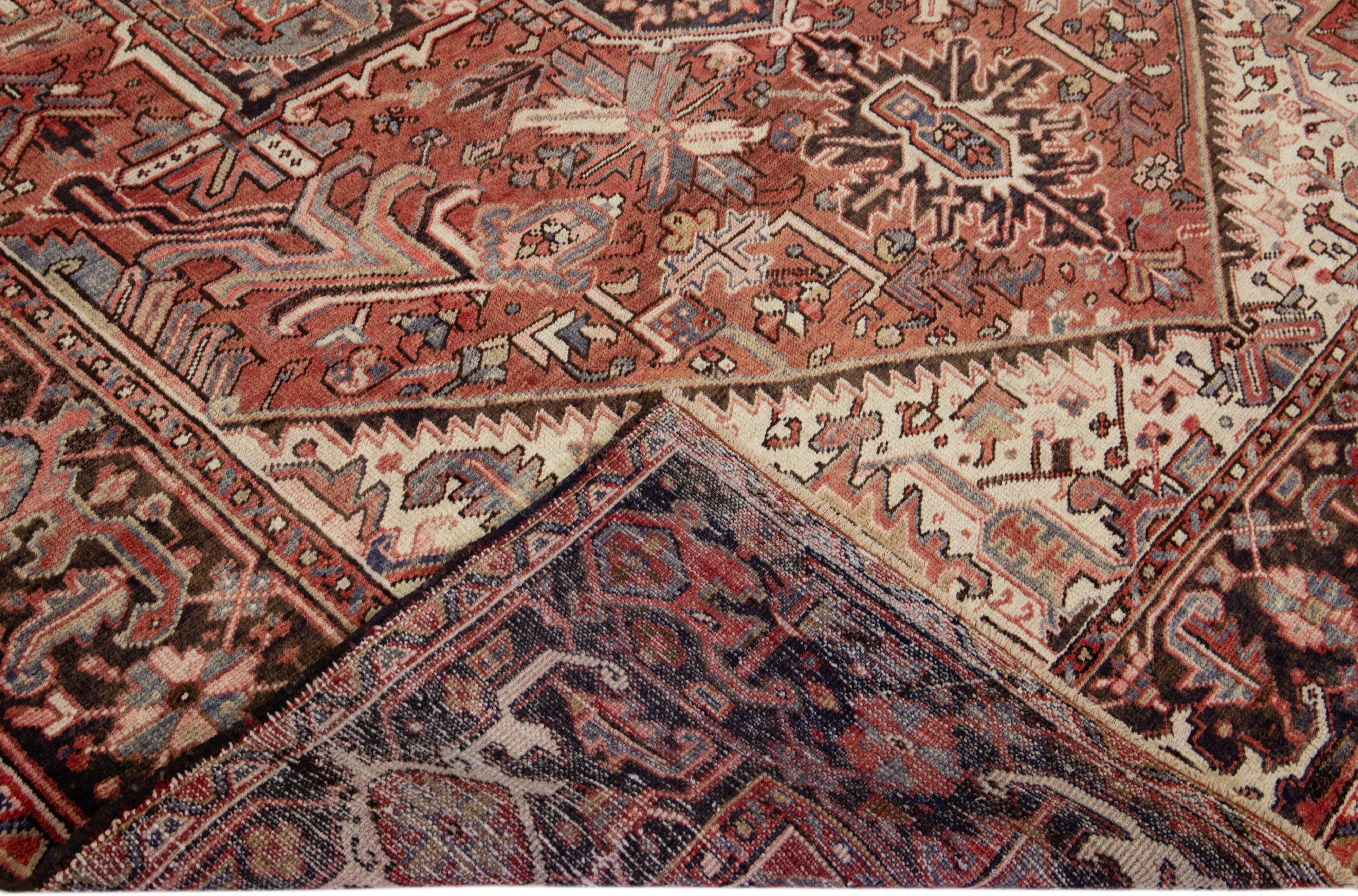 Magnifique tapis antique Heriz en laine nouée à la main avec un champ de couleur rouille. Ce tapis persan présente des accents gris, pêche et beige dans un magnifique motif floral en médaillon.

Ce tapis mesure : 9'7