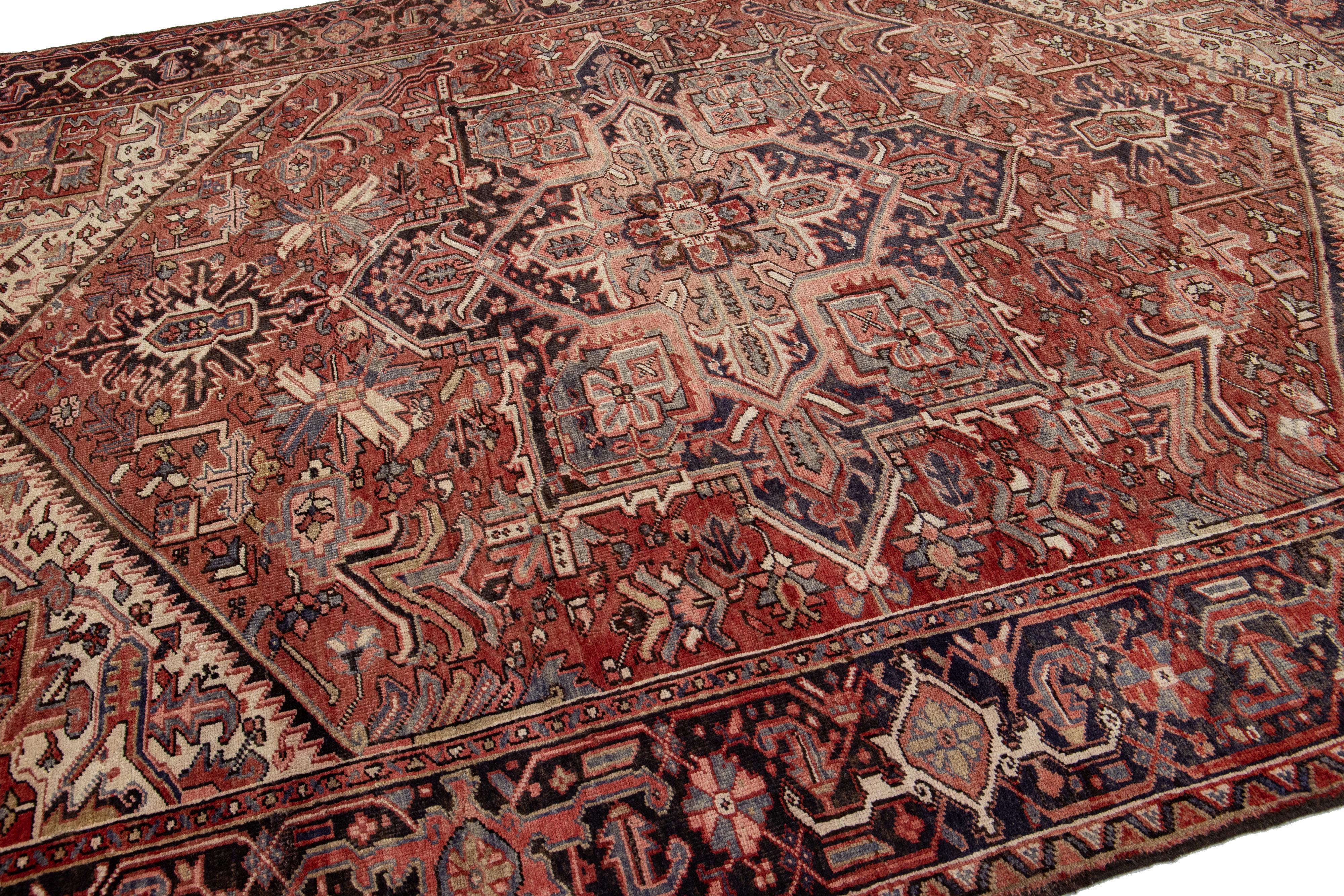 Noué à la main Tapis persan ancien Heriz en laine rouille fait à la main avec motif de médaillon en vente