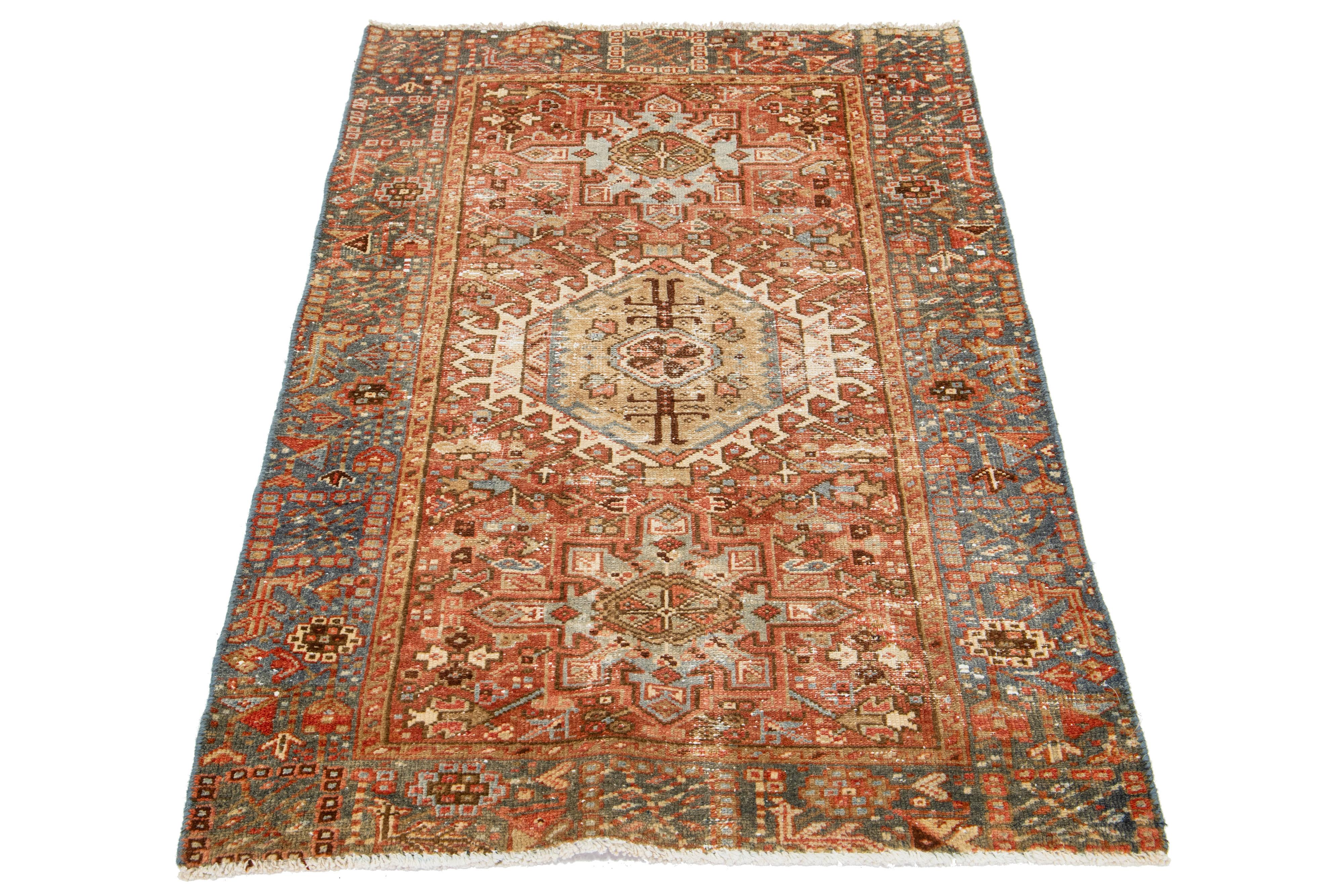 This antique Persian Heriz rug is crafted with hand-knotted wool. The rust field features a captivating medallion pattern embellished with beige, peach, and brown shades.

This rug measures 3' x 4'6