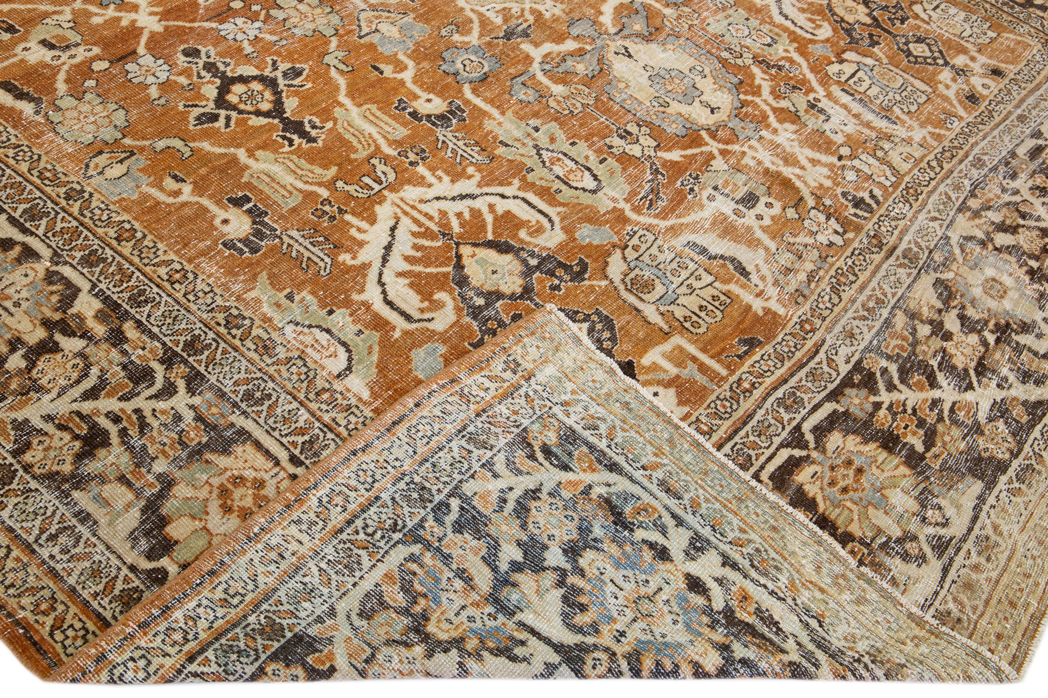 A beautiful Antique Mahal hand-knotted wool rug with a rust color field. This rug has a brown frame and multicolor accents in an all-over geometric floral design.

This rug measures 10'6