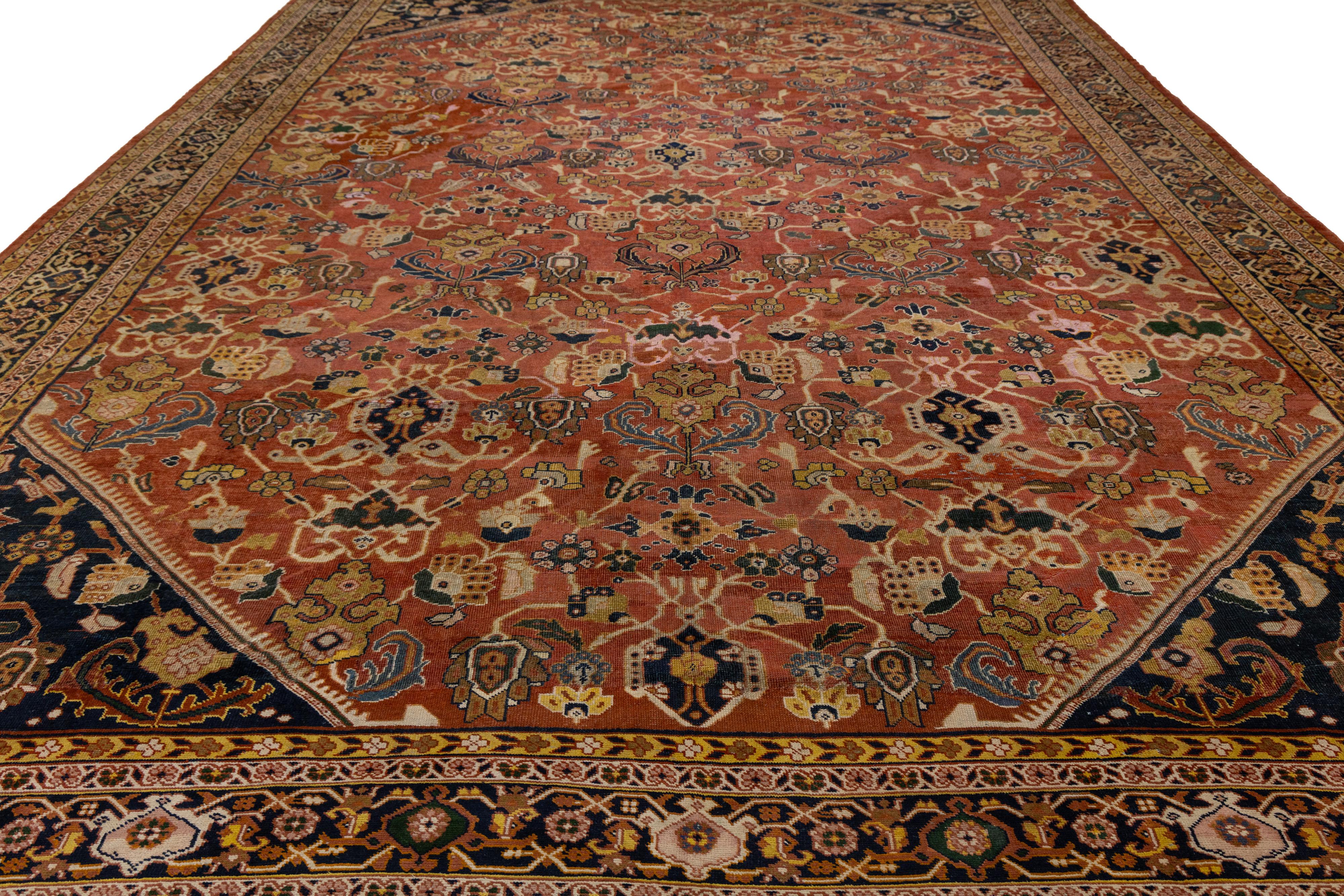 A richly expressive turn-of-the-century Persian Mahal, this handwoven masterpiece showcases the hallmarks of early 20th-century village craftsmanship. The spacious field is rendered in a warm, reddish-brown tone, anchored by a striking hexagonal
