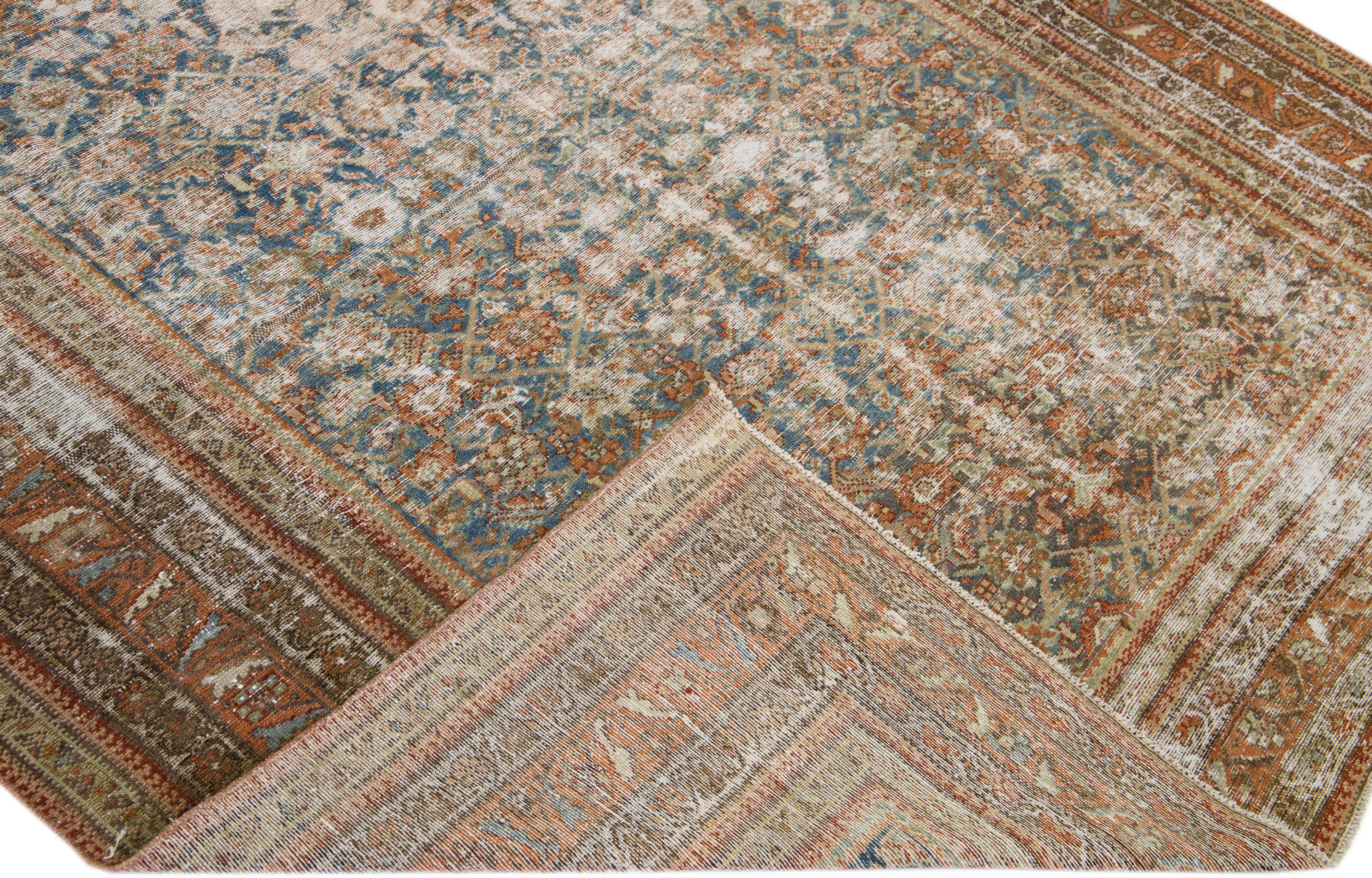 Beautiful antique Malayer hand-knotted wool rug with a blue field. This Persian piece has orange-rust and brown accent colors in a gorgeous all-over floral design.

This rug measures: 6'4