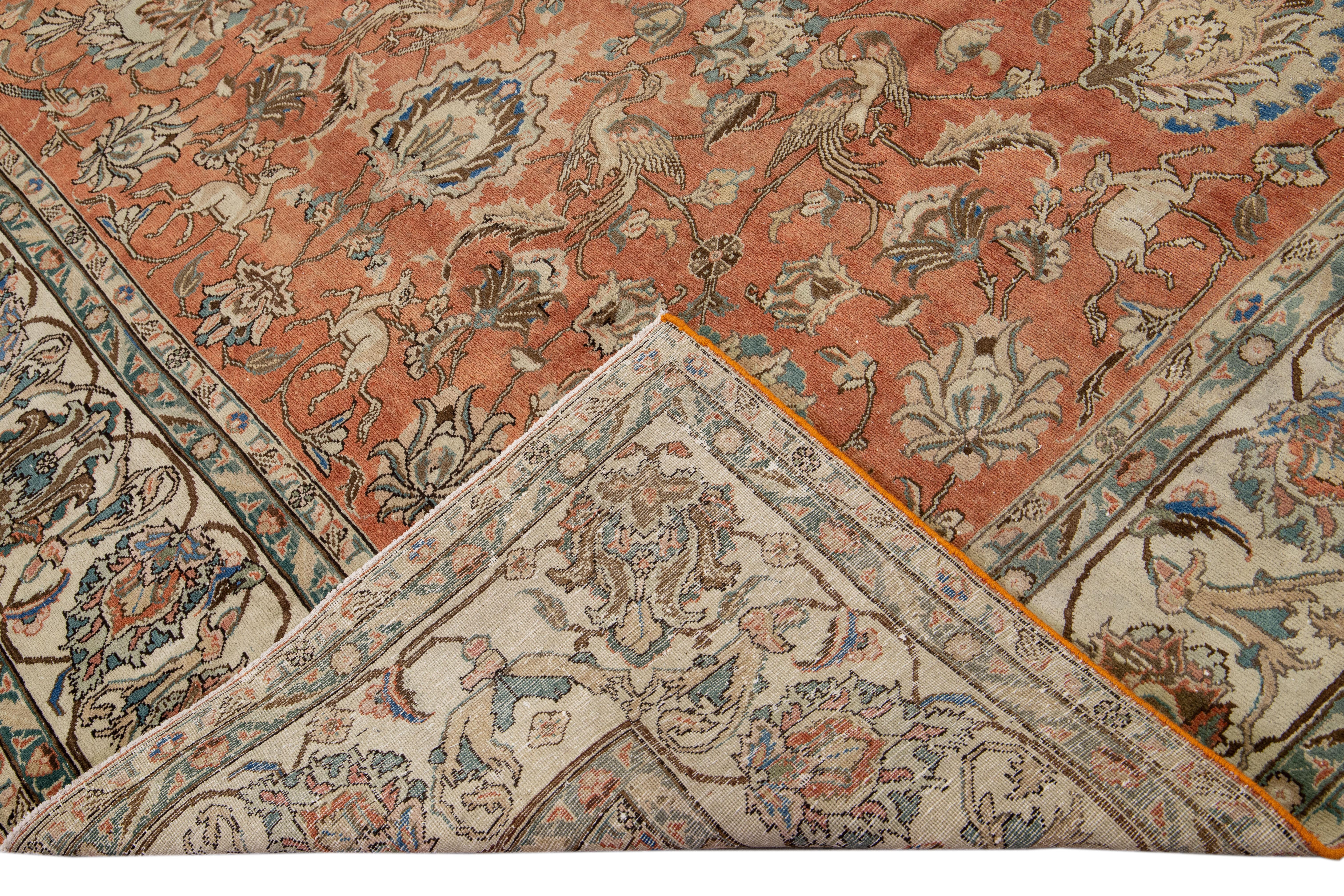 Preciosa alfombra persa antigua Tabriz de lana anudada a mano con un campo de óxido. Esta pieza tiene un marco beige y detalles multicolores en un precioso diseño floral integral.

Esta alfombra mide 9'5