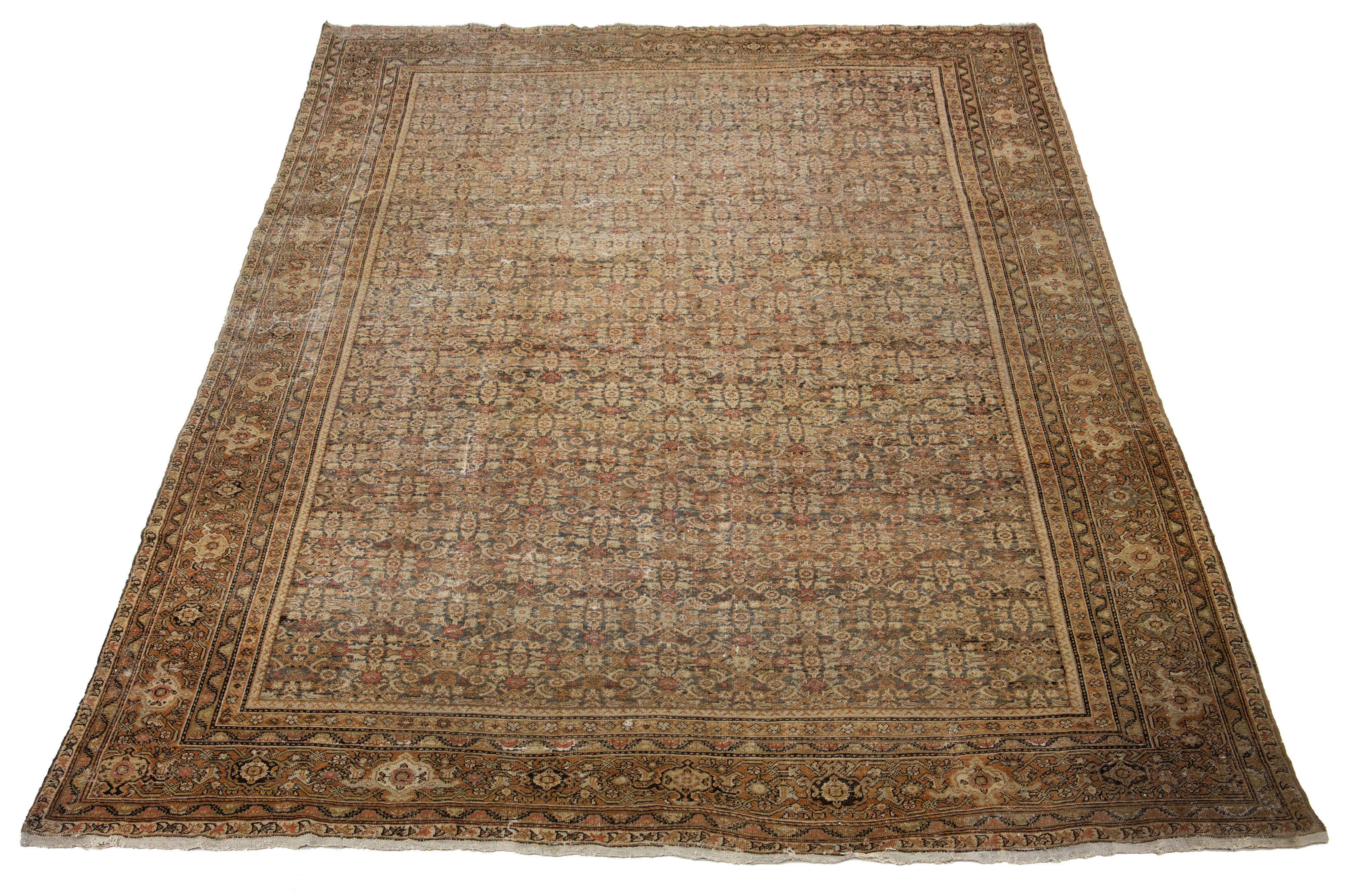 An antique Persian Tabriz rug featuring a blue-gray field with orange, beige, and rust accents adorned with an all-over pattern.

This rug measures 11'6